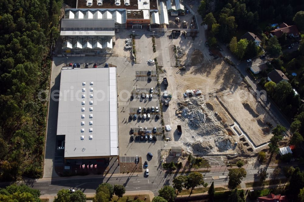 Aerial photograph Hohen Neuendorf - Construction site of a new shopping center and store of the Supermarket REWE in Hohen Neuendorf in the state of Brandenburg. A new shopping facility with stores is being built as part of the regeneration of the shopping center HDZ on Schoenfliesser Strasse. The project is carried out by GVG Projektentwicklungsgesellschaft mbH