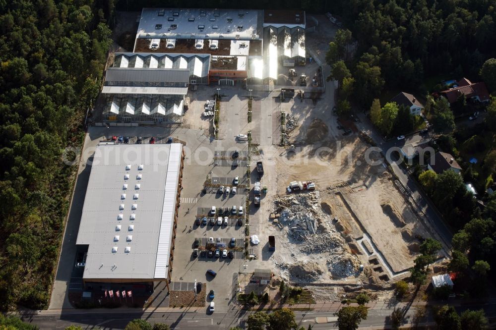 Hohen Neuendorf from above - Construction site of a new shopping center and store of the Supermarket REWE in Hohen Neuendorf in the state of Brandenburg. A new shopping facility with stores is being built as part of the regeneration of the shopping center HDZ on Schoenfliesser Strasse. The project is carried out by GVG Projektentwicklungsgesellschaft mbH