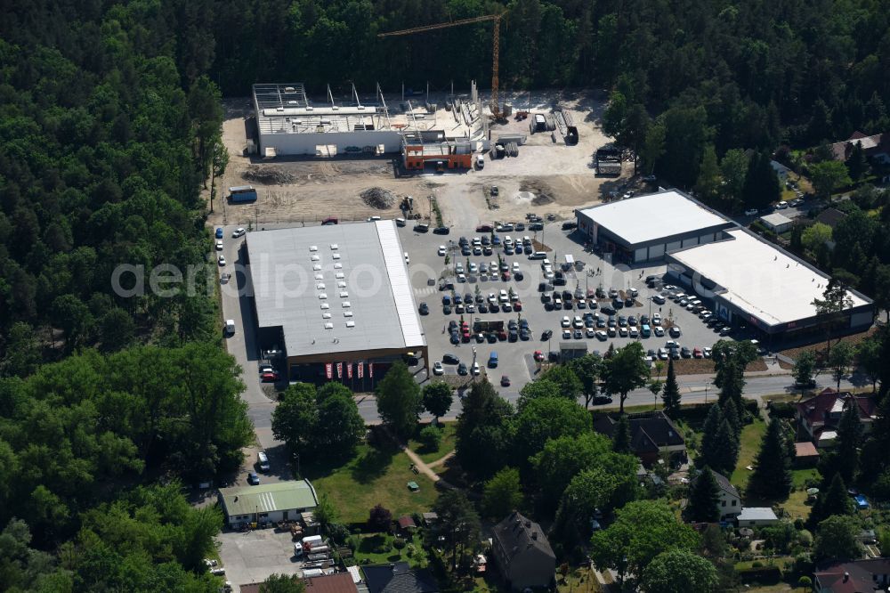 Aerial image Hohen Neuendorf - Construction site of a new shopping center and store of the Supermarket REWE in Hohen Neuendorf in the state of Brandenburg. A new shopping facility with stores is being built as part of the regeneration of the shopping center HDZ on Schoenfliesser Strasse. The project is carried out by GVG Projektentwicklungsgesellschaft mbH