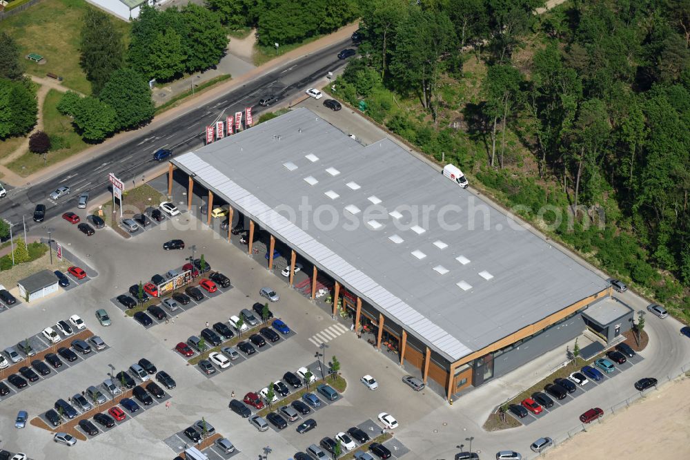 Aerial image Hohen Neuendorf - Construction site of a new shopping center and store of the Supermarket REWE in Hohen Neuendorf in the state of Brandenburg. A new shopping facility with stores is being built as part of the regeneration of the shopping center HDZ on Schoenfliesser Strasse. The project is carried out by GVG Projektentwicklungsgesellschaft mbH