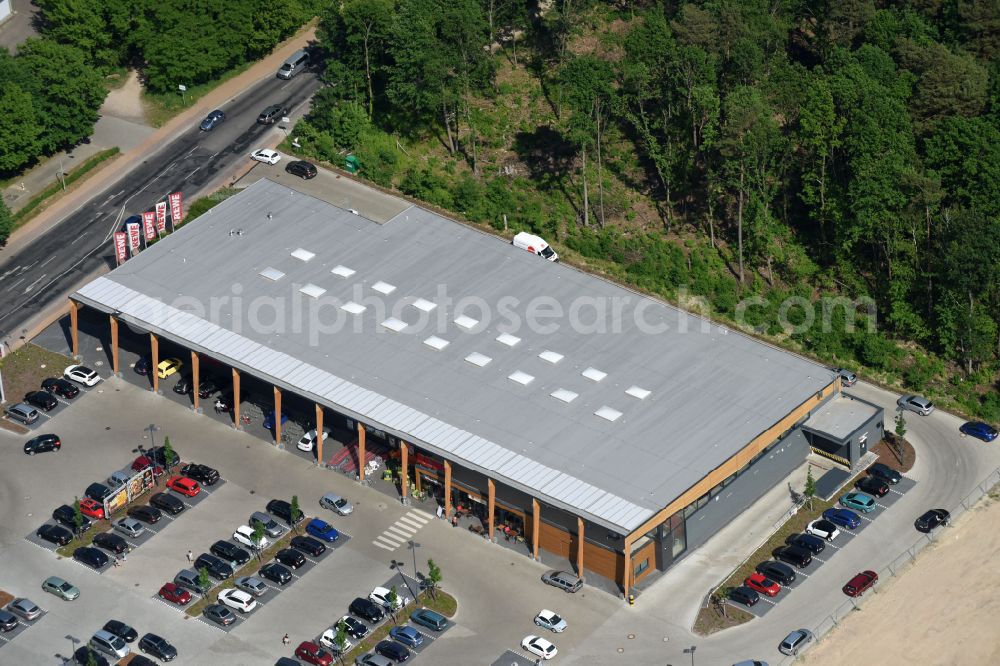 Aerial photograph Hohen Neuendorf - Construction site of a new shopping center and store of the Supermarket REWE in Hohen Neuendorf in the state of Brandenburg. A new shopping facility with stores is being built as part of the regeneration of the shopping center HDZ on Schoenfliesser Strasse. The project is carried out by GVG Projektentwicklungsgesellschaft mbH