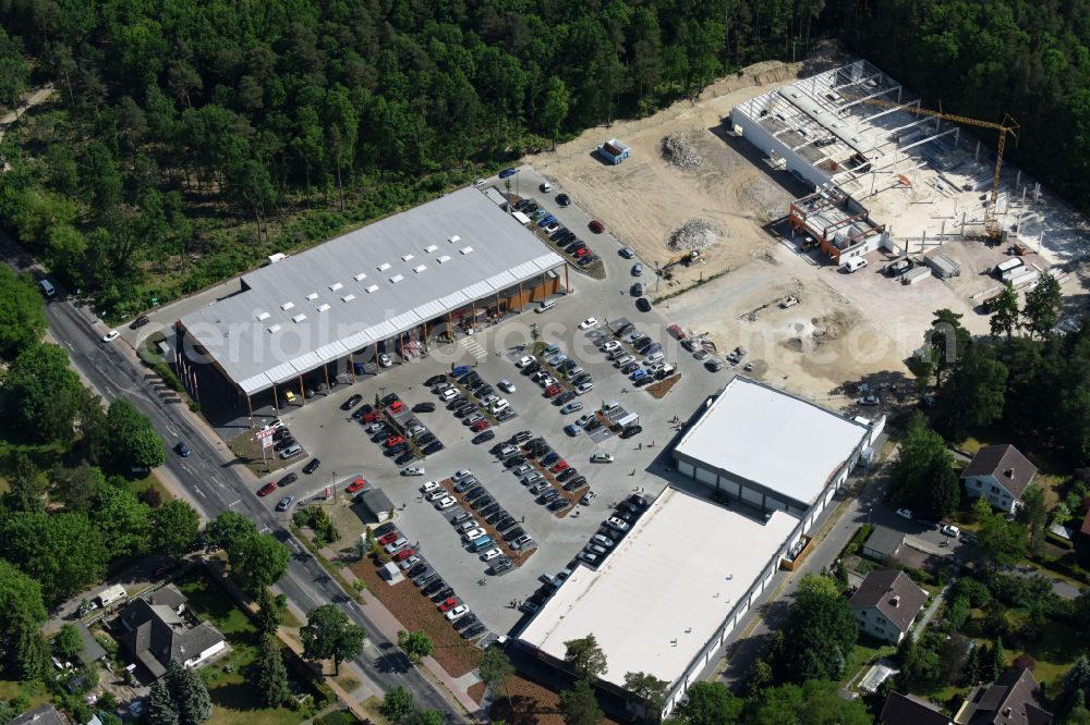 Aerial image Hohen Neuendorf - Construction site of a new shopping center and store of the Supermarket REWE in Hohen Neuendorf in the state of Brandenburg. A new shopping facility with stores is being built as part of the regeneration of the shopping center HDZ on Schoenfliesser Strasse. The project is carried out by GVG Projektentwicklungsgesellschaft mbH