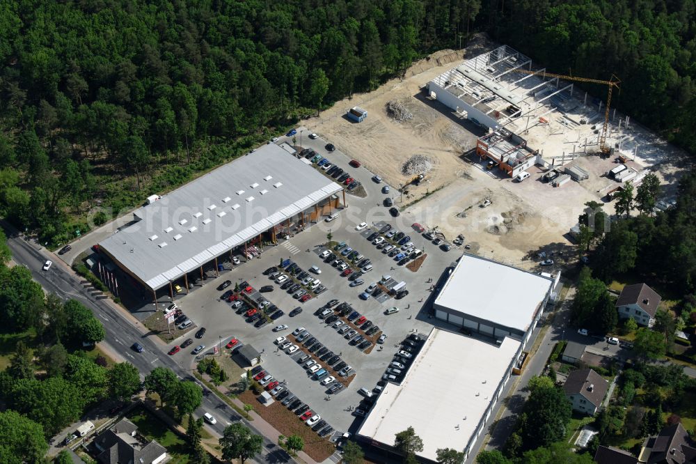 Aerial photograph Hohen Neuendorf - Construction site of a new shopping center and store of the Supermarket REWE in Hohen Neuendorf in the state of Brandenburg. A new shopping facility with stores is being built as part of the regeneration of the shopping center HDZ on Schoenfliesser Strasse. The project is carried out by GVG Projektentwicklungsgesellschaft mbH