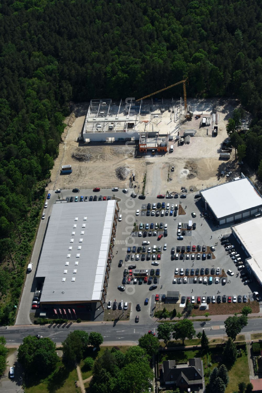 Hohen Neuendorf from above - Construction site of a new shopping center and store of the Supermarket REWE in Hohen Neuendorf in the state of Brandenburg. A new shopping facility with stores is being built as part of the regeneration of the shopping center HDZ on Schoenfliesser Strasse. The project is carried out by GVG Projektentwicklungsgesellschaft mbH