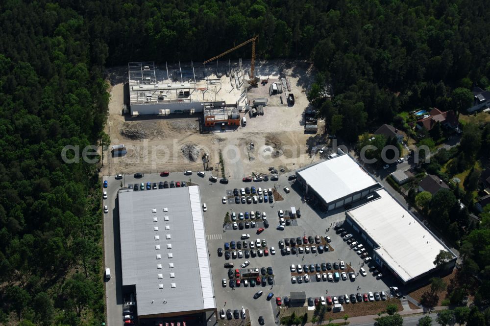 Aerial image Hohen Neuendorf - Construction site of a new shopping center and store of the Supermarket REWE in Hohen Neuendorf in the state of Brandenburg. A new shopping facility with stores is being built as part of the regeneration of the shopping center HDZ on Schoenfliesser Strasse. The project is carried out by GVG Projektentwicklungsgesellschaft mbH