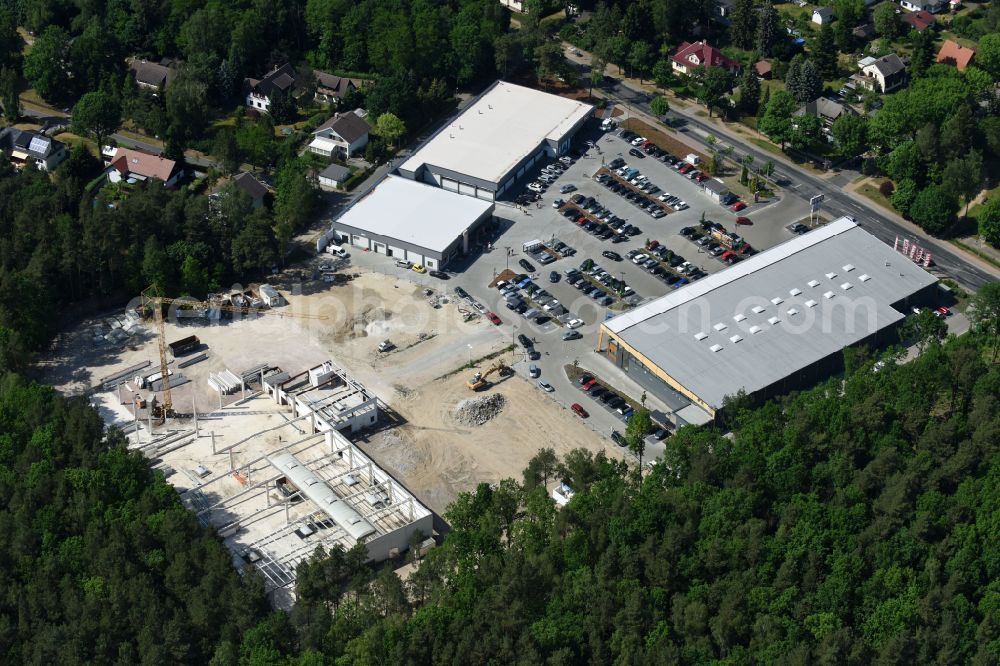 Aerial photograph Hohen Neuendorf - Construction site of a new shopping center and store of the Supermarket REWE in Hohen Neuendorf in the state of Brandenburg. A new shopping facility with stores is being built as part of the regeneration of the shopping center HDZ on Schoenfliesser Strasse. The project is carried out by GVG Projektentwicklungsgesellschaft mbH