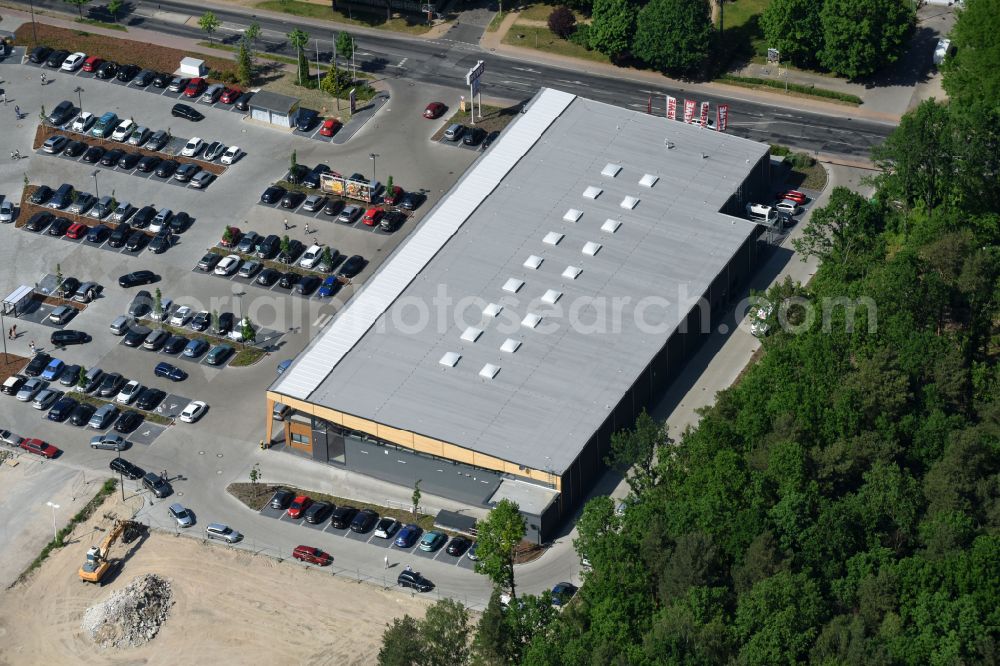 Hohen Neuendorf from the bird's eye view: Construction site of a new shopping center and store of the Supermarket REWE in Hohen Neuendorf in the state of Brandenburg. A new shopping facility with stores is being built as part of the regeneration of the shopping center HDZ on Schoenfliesser Strasse. The project is carried out by GVG Projektentwicklungsgesellschaft mbH