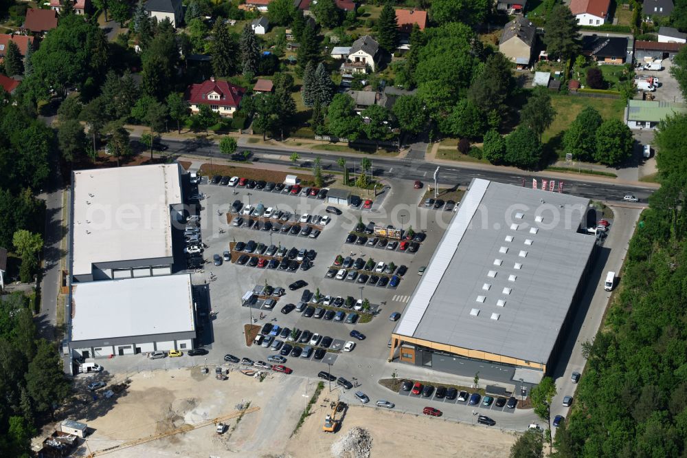 Aerial image Hohen Neuendorf - Construction site of a new shopping center and store of the Supermarket REWE in Hohen Neuendorf in the state of Brandenburg. A new shopping facility with stores is being built as part of the regeneration of the shopping center HDZ on Schoenfliesser Strasse. The project is carried out by GVG Projektentwicklungsgesellschaft mbH