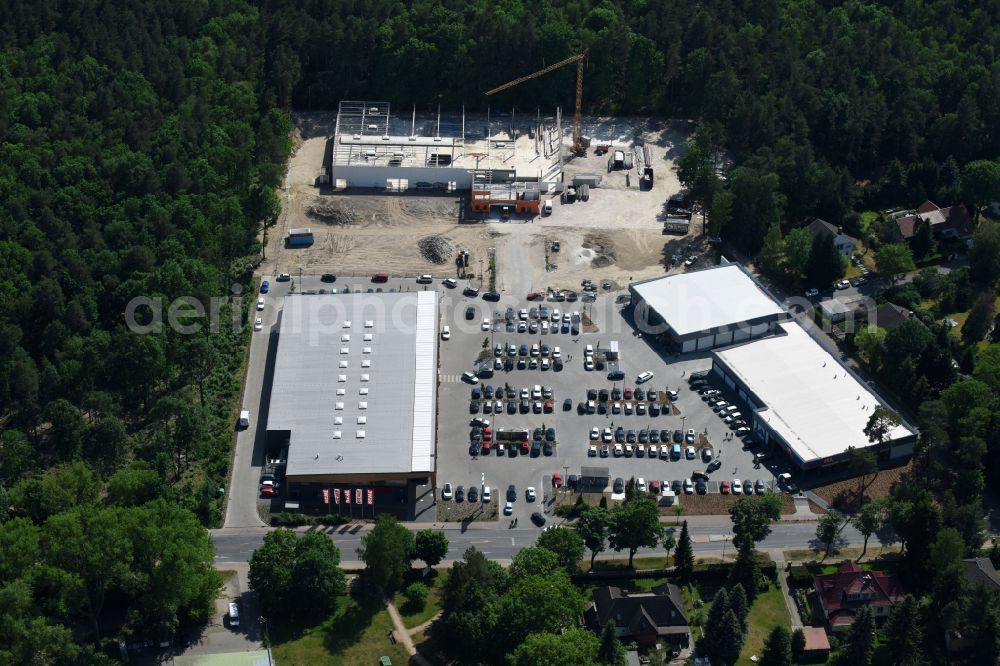 Hohen Neuendorf from above - Construction site of a new shopping center and store of the Supermarket REWE in Hohen Neuendorf in the state of Brandenburg. A new shopping facility with stores is being built as part of the regeneration of the shopping center HDZ on Schoenfliesser Strasse. The project is carried out by GVG Projektentwicklungsgesellschaft mbH