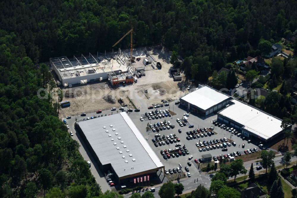 Aerial image Hohen Neuendorf - Construction site of a new shopping center and store of the Supermarket REWE in Hohen Neuendorf in the state of Brandenburg. A new shopping facility with stores is being built as part of the regeneration of the shopping center HDZ on Schoenfliesser Strasse. The project is carried out by GVG Projektentwicklungsgesellschaft mbH