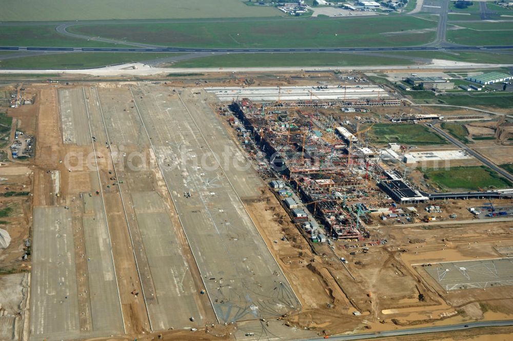 Aerial photograph Schönefeld - Blick auf die Baustelle des neuen Fern- und S-Bahnhofes der Deutschen Bahn auf der Großbaustelle Neubau Bahnhof BBI (SXF) am Flughafen Berlin - Schönefeld. Ausführende Firmen: Hochtief AG; EUROVIA Beton; PORR; BERGER Bau; Kark Weiss; Matthai; Schäler Bau Berlin GmbH; STRABAG; MAX BÖGL