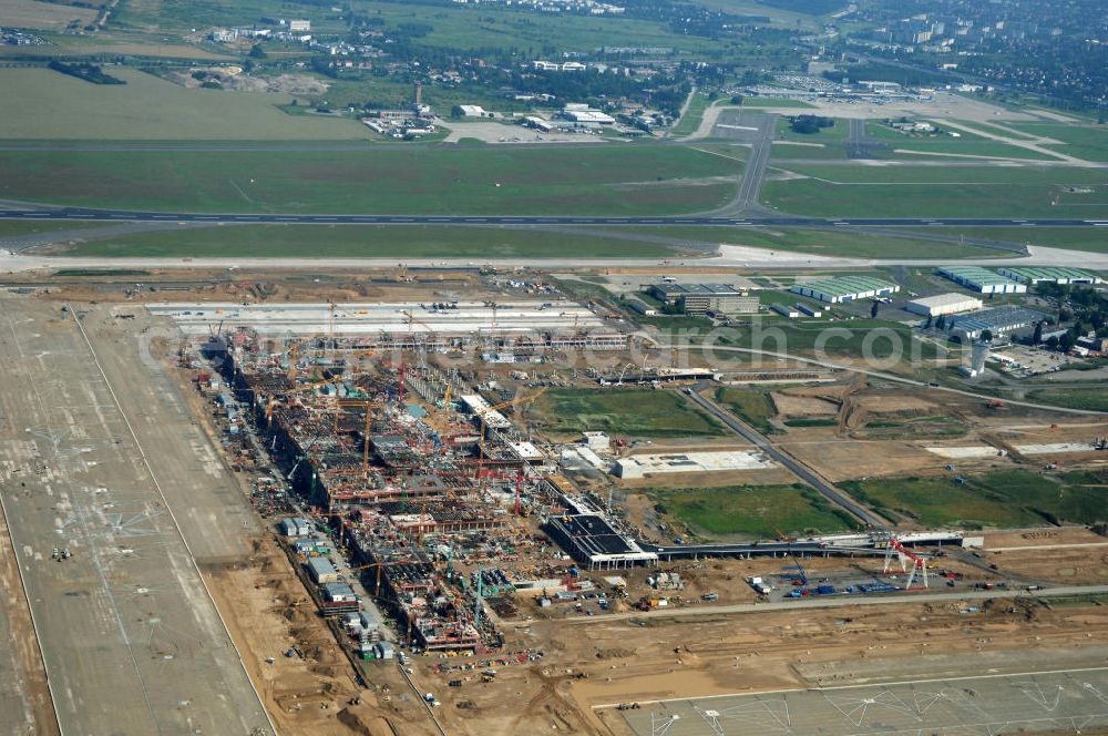 Schönefeld from the bird's eye view: Blick auf die Baustelle des neuen Fern- und S-Bahnhofes der Deutschen Bahn auf der Großbaustelle Neubau Bahnhof BBI (SXF) am Flughafen Berlin - Schönefeld. Ausführende Firmen: Hochtief AG; EUROVIA Beton; PORR; BERGER Bau; Kark Weiss; Matthai; Schäler Bau Berlin GmbH; STRABAG; MAX BÖGL