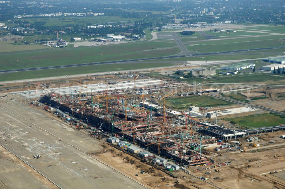 Aerial photograph Schönefeld - Blick auf die Baustelle des neuen Fern- und S-Bahnhofes der Deutschen Bahn auf der Großbaustelle Neubau Bahnhof BBI (SXF) am Flughafen Berlin - Schönefeld. Ausführende Firmen: Hochtief AG; EUROVIA Beton; PORR; BERGER Bau; Kark Weiss; Matthai; Schäler Bau Berlin GmbH; STRABAG; MAX BÖGL