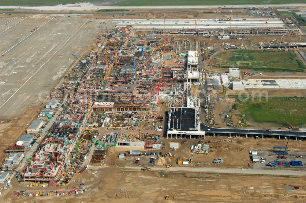 Aerial photograph Schönefeld - Blick auf die Baustelle des neuen Fern- und S-Bahnhofes der Deutschen Bahn auf der Großbaustelle Neubau Bahnhof BBI (SXF) am Flughafen Berlin - Schönefeld. Ausführende Firmen: Hochtief AG; EUROVIA Beton; PORR; BERGER Bau; Kark Weiss; Matthai; Schäler Bau Berlin GmbH; STRABAG; MAX BÖGL