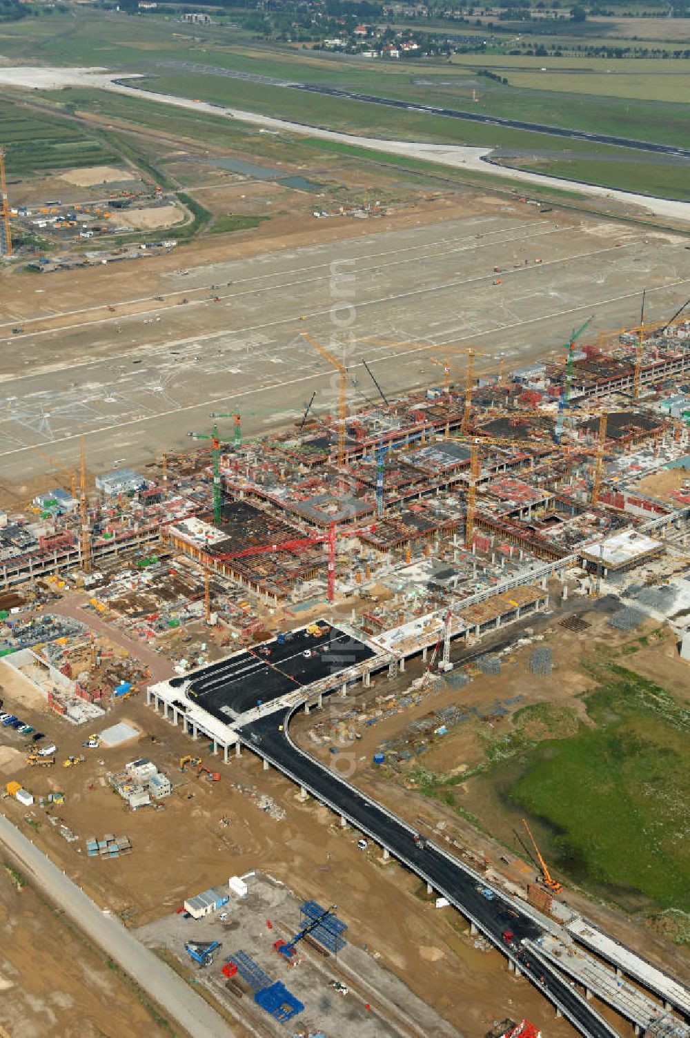 Schönefeld from the bird's eye view: Blick auf die Baustelle des neuen Fern- und S-Bahnhofes der Deutschen Bahn auf der Großbaustelle Neubau Bahnhof BBI (SXF) am Flughafen Berlin - Schönefeld. Ausführende Firmen: Hochtief AG; EUROVIA Beton; PORR; BERGER Bau; Kark Weiss; Matthai; Schäler Bau Berlin GmbH; STRABAG; MAX BÖGL