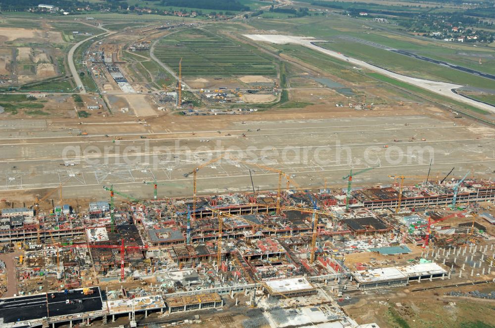 Schönefeld from the bird's eye view: Blick auf die Baustelle des neuen Fern- und S-Bahnhofes der Deutschen Bahn auf der Großbaustelle Neubau Bahnhof BBI (SXF) am Flughafen Berlin - Schönefeld. Ausführende Firmen: Hochtief AG; EUROVIA Beton; PORR; BERGER Bau; Kark Weiss; Matthai; Schäler Bau Berlin GmbH; STRABAG; MAX BÖGL