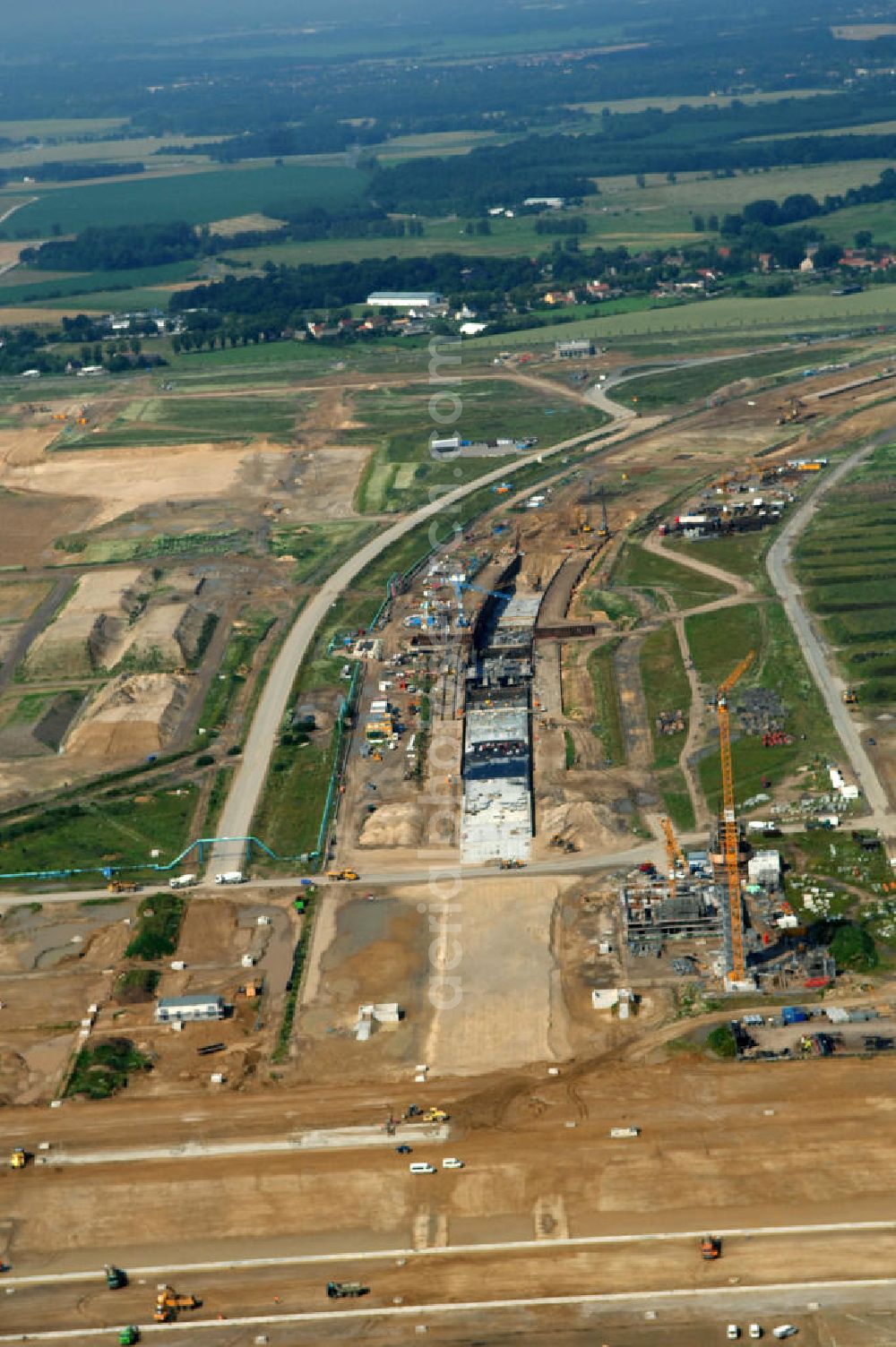 Aerial photograph Schönefeld - Blick auf die Baustelle des neuen Fern- und S-Bahnhofes der Deutschen Bahn auf der Großbaustelle Neubau Bahnhof BBI (SXF) am Flughafen Berlin - Schönefeld. Ausführende Firmen: Hochtief AG; EUROVIA Beton; PORR; BERGER Bau; Kark Weiss; Matthai; Schäler Bau Berlin GmbH; STRABAG; MAX BÖGL