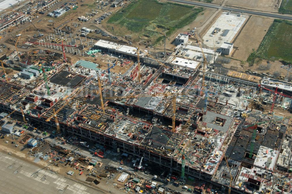 Aerial photograph Schönefeld - Blick auf die Baustelle des neuen Fern- und S-Bahnhofes der Deutschen Bahn auf der Großbaustelle Neubau Bahnhof BBI (SXF) am Flughafen Berlin - Schönefeld. Ausführende Firmen: Hochtief AG; EUROVIA Beton; PORR; BERGER Bau; Kark Weiss; Matthai; Schäler Bau Berlin GmbH; STRABAG; MAX BÖGL