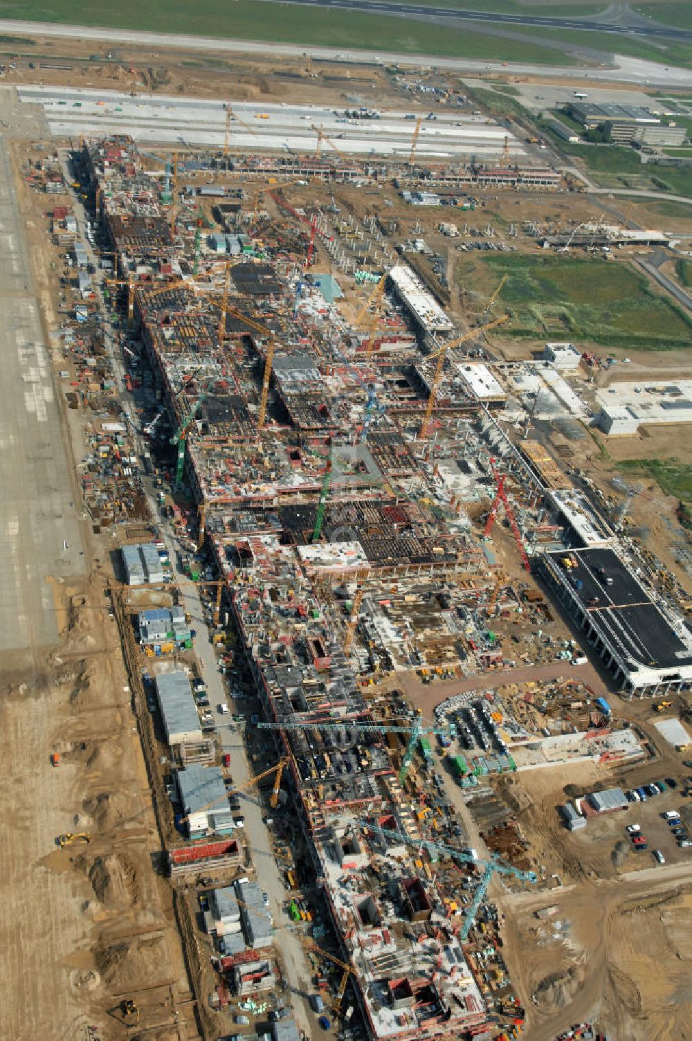 Schönefeld from the bird's eye view: Blick auf die Baustelle des neuen Fern- und S-Bahnhofes der Deutschen Bahn auf der Großbaustelle Neubau Bahnhof BBI (SXF) am Flughafen Berlin - Schönefeld. Ausführende Firmen: Hochtief AG; EUROVIA Beton; PORR; BERGER Bau; Kark Weiss; Matthai; Schäler Bau Berlin GmbH; STRABAG; MAX BÖGL