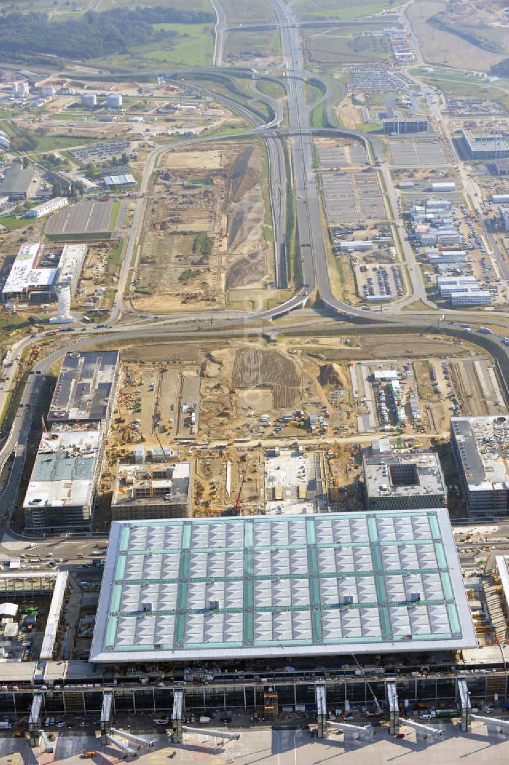 Aerial photograph Berlin Schönefeld - Baustelle des neuen Terminals am Flughafen Schönefeld (BBI). Der neue Terminal wird südlich des jetzigen Flughafens Berlin- Schönefeld errichtet. Ausführende Firmen: Hochtief AG; EUROVIA Beton; PORR; BERGER Bau; Karl Weiss; Matthai; Schäler Bau Berlin GmbH; STRABAG; Construction area of the new terminal at Schönefeld Airport (BBI). The new terminal is in the south of the airport Berlin -Schoenefeld quality built. Exporting companies: Hochtief AG; EUROVIA Beton; PORR; BERGER Bau; Karl Weiss; Matthai; Schäler Bau Berlin GmbH; STRABAG;