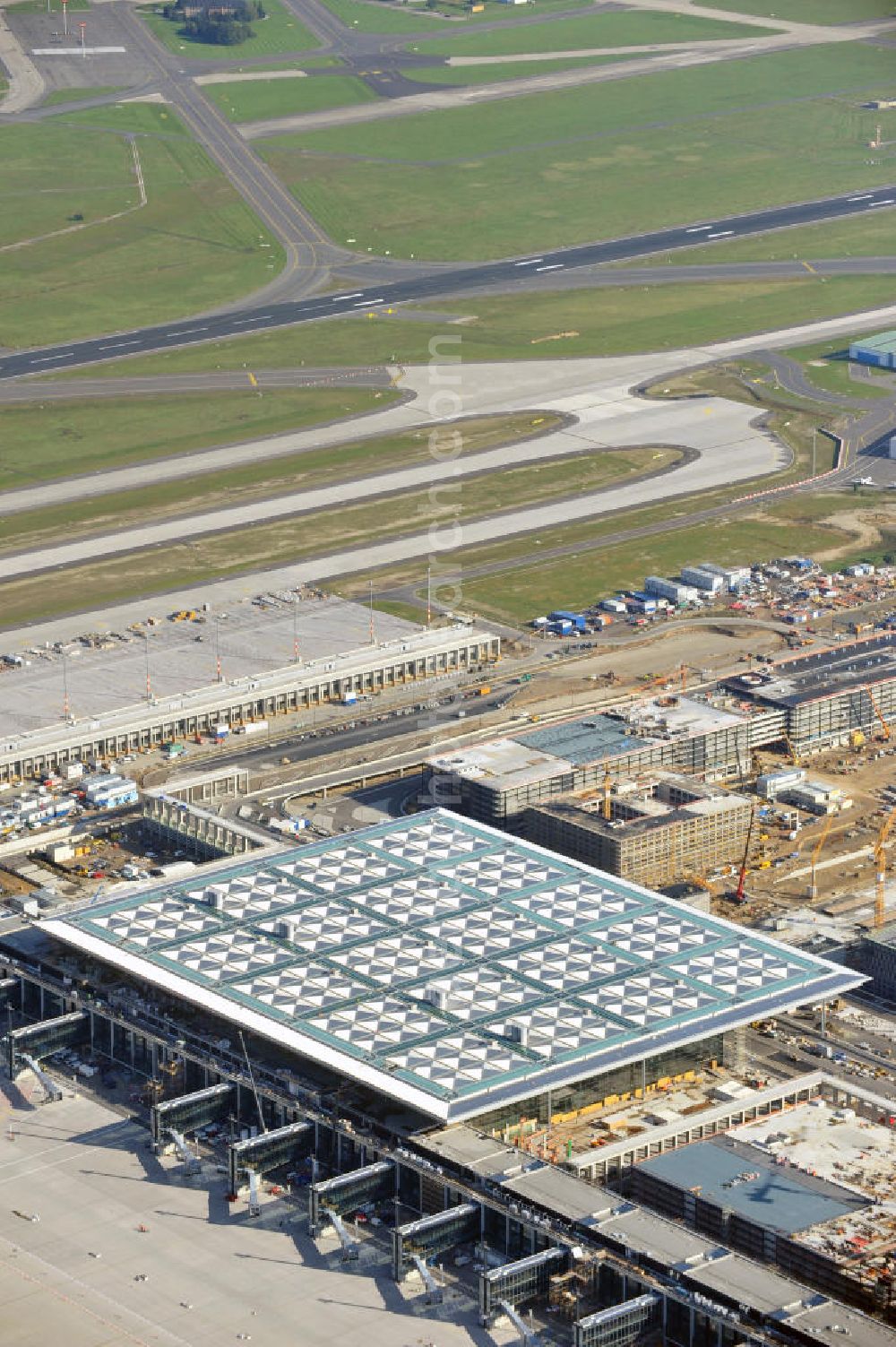 Berlin Schönefeld from the bird's eye view: Baustelle des neuen Terminals am Flughafen Schönefeld (BBI). Der neue Terminal wird südlich des jetzigen Flughafens Berlin- Schönefeld errichtet. Ausführende Firmen: Hochtief AG; EUROVIA Beton; PORR; BERGER Bau; Karl Weiss; Matthai; Schäler Bau Berlin GmbH; STRABAG; Construction area of the new terminal at Schönefeld Airport (BBI). The new terminal is in the south of the airport Berlin -Schoenefeld quality built. Exporting companies: Hochtief AG; EUROVIA Beton; PORR; BERGER Bau; Karl Weiss; Matthai; Schäler Bau Berlin GmbH; STRABAG;