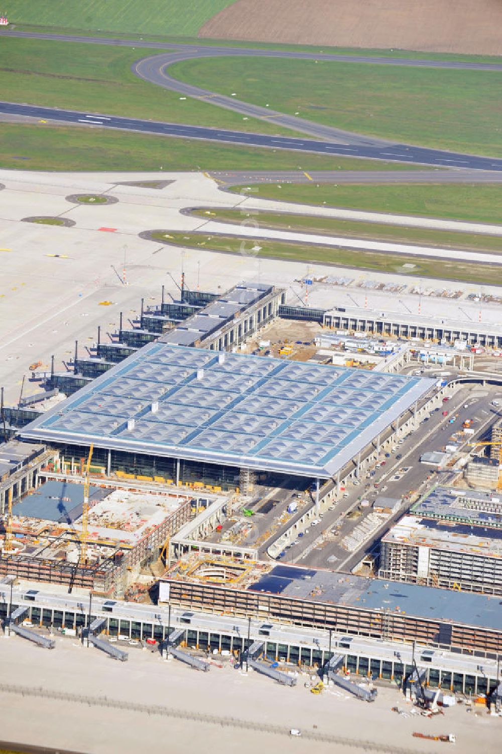 Aerial photograph Berlin Schönefeld - Baustelle des neuen Terminals am Flughafen Schönefeld (BBI). Der neue Terminal wird südlich des jetzigen Flughafens Berlin- Schönefeld errichtet. Ausführende Firmen: Hochtief AG; EUROVIA Beton; PORR; BERGER Bau; Karl Weiss; Matthai; Schäler Bau Berlin GmbH; STRABAG; Construction area of the new terminal at Schönefeld Airport (BBI). The new terminal is in the south of the airport Berlin -Schoenefeld quality built. Exporting companies: Hochtief AG; EUROVIA Beton; PORR; BERGER Bau; Karl Weiss; Matthai; Schäler Bau Berlin GmbH; STRABAG;