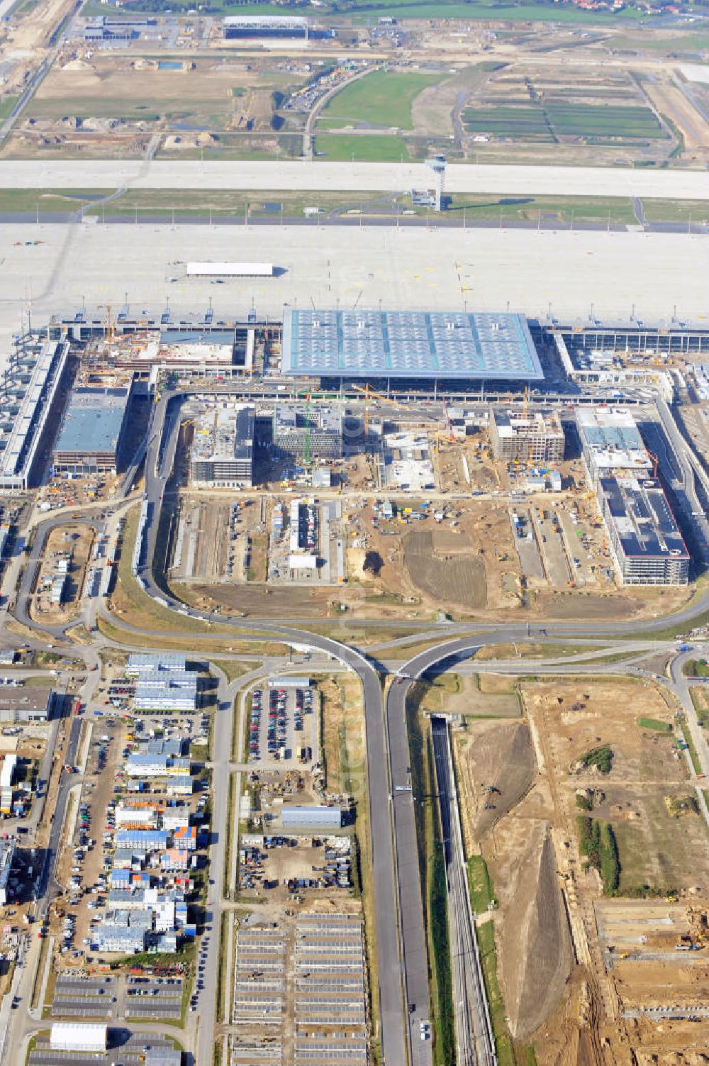 Berlin Schönefeld from the bird's eye view: Baustelle des neuen Terminals am Flughafen Schönefeld (BBI). Der neue Terminal wird südlich des jetzigen Flughafens Berlin- Schönefeld errichtet. Ausführende Firmen: Hochtief AG; EUROVIA Beton; PORR; BERGER Bau; Karl Weiss; Matthai; Schäler Bau Berlin GmbH; STRABAG; Construction area of the new terminal at Schönefeld Airport (BBI). The new terminal is in the south of the airport Berlin -Schoenefeld quality built. Exporting companies: Hochtief AG; EUROVIA Beton; PORR; BERGER Bau; Karl Weiss; Matthai; Schäler Bau Berlin GmbH; STRABAG;