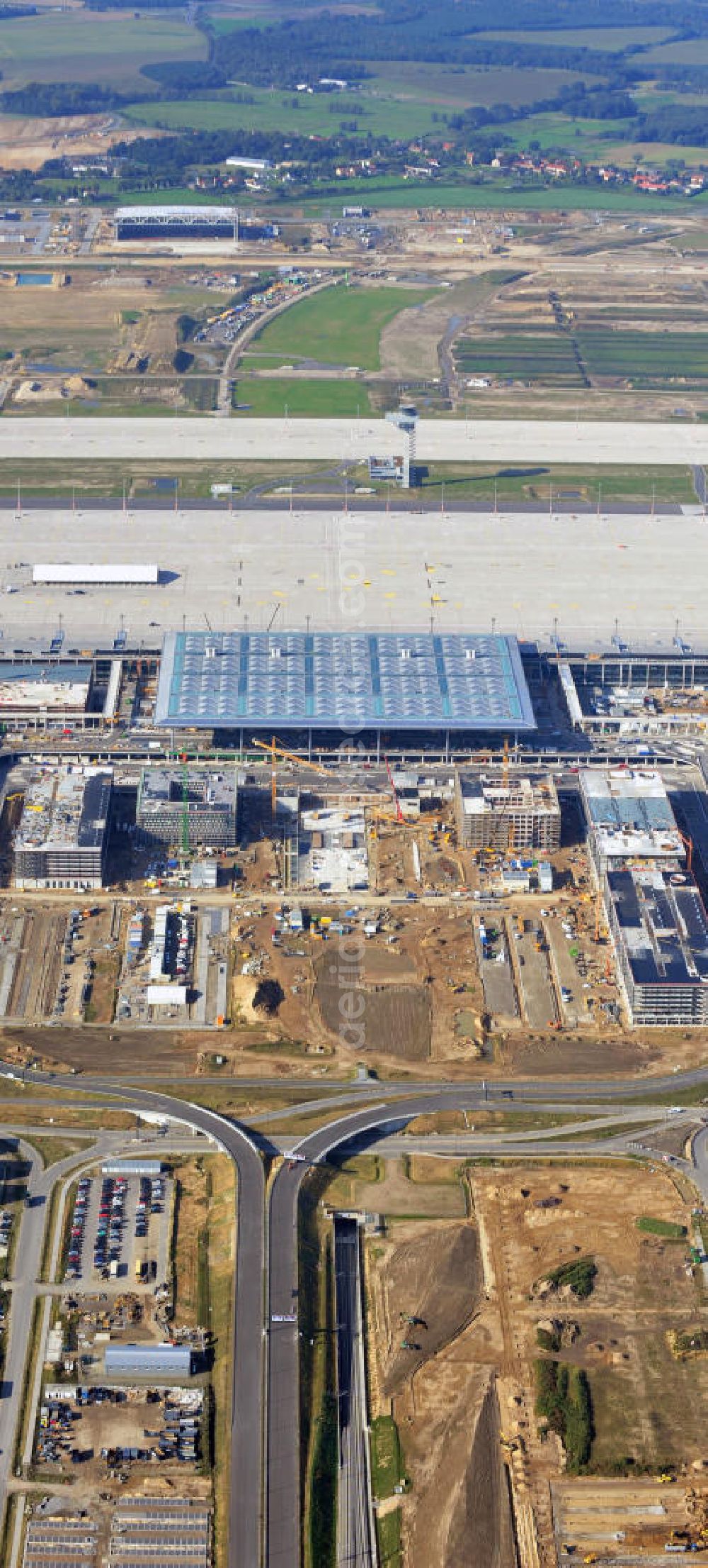 Aerial photograph Berlin Schönefeld - Baustelle des neuen Terminals am Flughafen Schönefeld (BBI). Der neue Terminal wird südlich des jetzigen Flughafens Berlin- Schönefeld errichtet. Ausführende Firmen: Hochtief AG; EUROVIA Beton; PORR; BERGER Bau; Karl Weiss; Matthai; Schäler Bau Berlin GmbH; STRABAG; Construction area of the new terminal at Schönefeld Airport (BBI). The new terminal is in the south of the airport Berlin -Schoenefeld quality built. Exporting companies: Hochtief AG; EUROVIA Beton; PORR; BERGER Bau; Karl Weiss; Matthai; Schäler Bau Berlin GmbH; STRABAG;