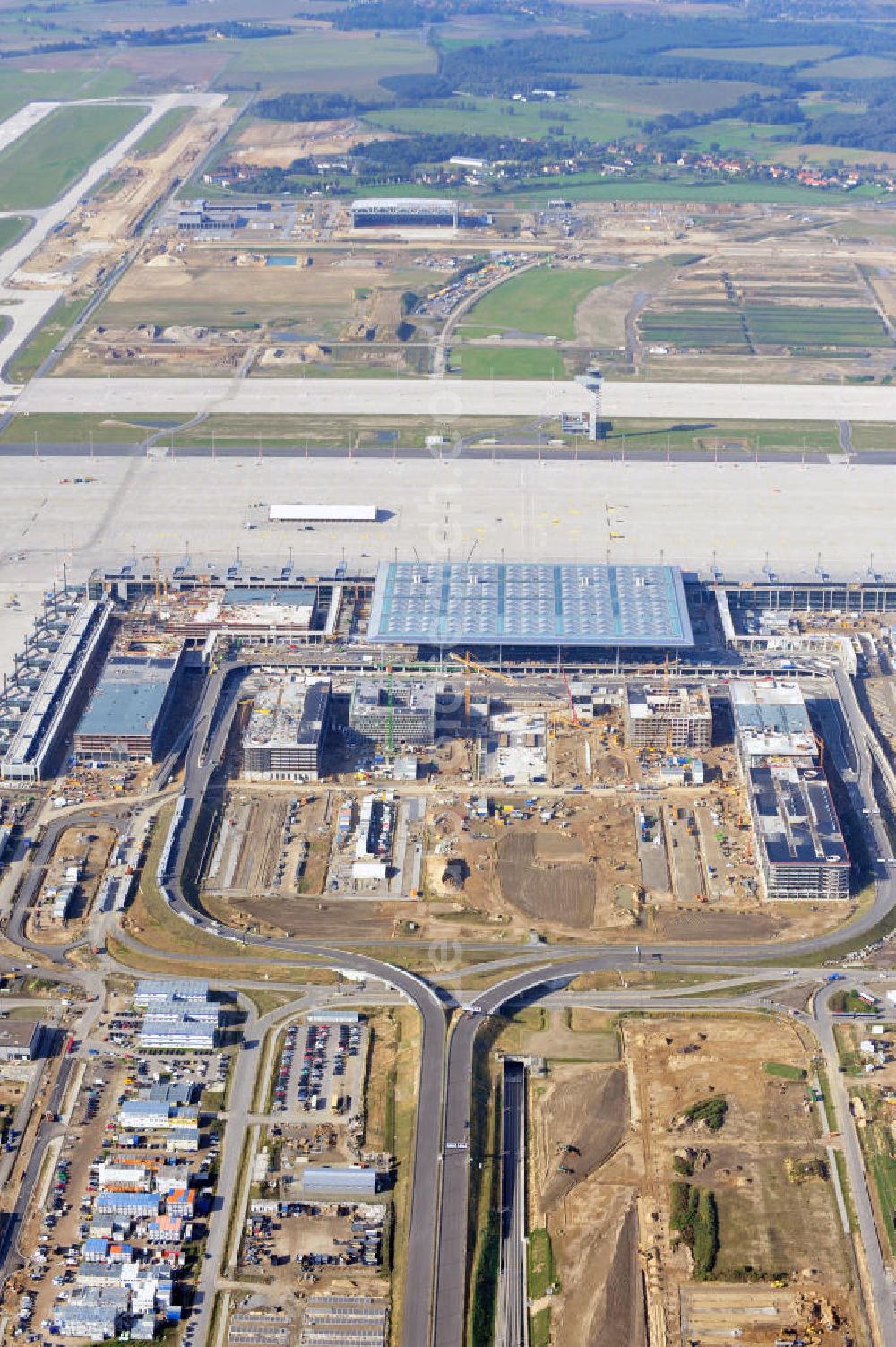 Berlin Schönefeld from above - Baustelle des neuen Terminals am Flughafen Schönefeld (BBI). Der neue Terminal wird südlich des jetzigen Flughafens Berlin- Schönefeld errichtet. Ausführende Firmen: Hochtief AG; EUROVIA Beton; PORR; BERGER Bau; Karl Weiss; Matthai; Schäler Bau Berlin GmbH; STRABAG; Construction area of the new terminal at Schönefeld Airport (BBI). The new terminal is in the south of the airport Berlin -Schoenefeld quality built. Exporting companies: Hochtief AG; EUROVIA Beton; PORR; BERGER Bau; Karl Weiss; Matthai; Schäler Bau Berlin GmbH; STRABAG;