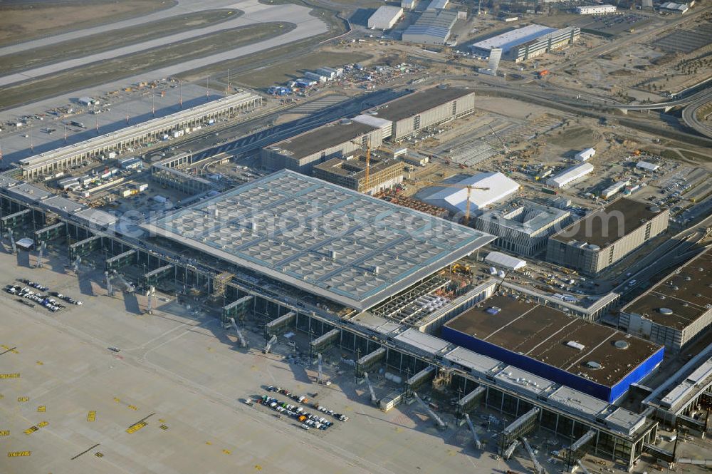 Aerial image Schönefeld - Baustelle des fast fertigen Terminals am Flughafen Schönefeld (BBI). Der neue Terminal wird südlich des jetzigen Flughafens Berlin- Schönefeld errichtet. Der Flughafen Berlin Brandenburg (IATA Code BER , ICAO Code EDDB) wird ein internationaler Verkehrsflughafen auf dem Gebiet der Gemeinde Schönefeld im Land Brandenburg. Er trägt den Beinamen Willy Brandt und soll durch die Flughafen Berlin Brandenburg GmbH betrieben werden. Beteiligte Baufirmen sind die Hochtief AG; EUROVIA Beton; PORR; BERGER Bau; Karl Weiss; Matthai; Schäler Bau Berlin GmbH; STRABAG; Construction area of the new terminal at Schönefeld Airport (BBI). The new terminal is in the south of the airport Berlin -Schoenefeld quality built. Exporting companies: Hochtief AG; EUROVIA Beton; PORR; BERGER Bau; Karl Weiss; Matthai; Schäler Bau Berlin GmbH; STRABAG;