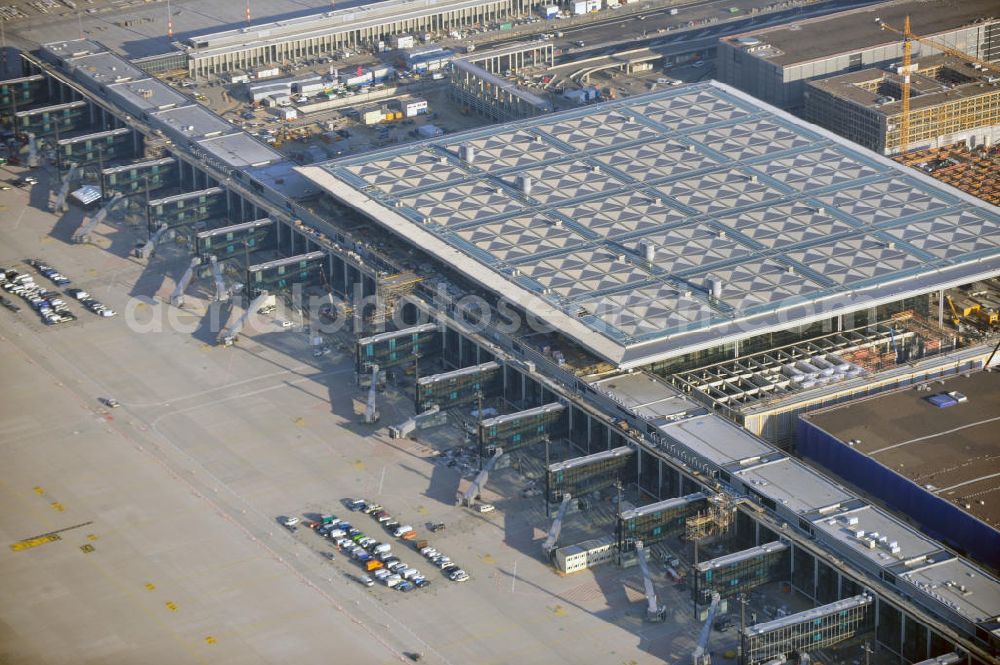 Aerial photograph Schönefeld - Baustelle des fast fertigen Terminals am Flughafen Schönefeld (BBI). Der neue Terminal wird südlich des jetzigen Flughafens Berlin- Schönefeld errichtet. Der Flughafen Berlin Brandenburg (IATA Code BER , ICAO Code EDDB) wird ein internationaler Verkehrsflughafen auf dem Gebiet der Gemeinde Schönefeld im Land Brandenburg. Er trägt den Beinamen Willy Brandt und soll durch die Flughafen Berlin Brandenburg GmbH betrieben werden. Beteiligte Baufirmen sind die Hochtief AG; EUROVIA Beton; PORR; BERGER Bau; Karl Weiss; Matthai; Schäler Bau Berlin GmbH; STRABAG; Construction area of the new terminal at Schönefeld Airport (BBI). The new terminal is in the south of the airport Berlin -Schoenefeld quality built. Exporting companies: Hochtief AG; EUROVIA Beton; PORR; BERGER Bau; Karl Weiss; Matthai; Schäler Bau Berlin GmbH; STRABAG;