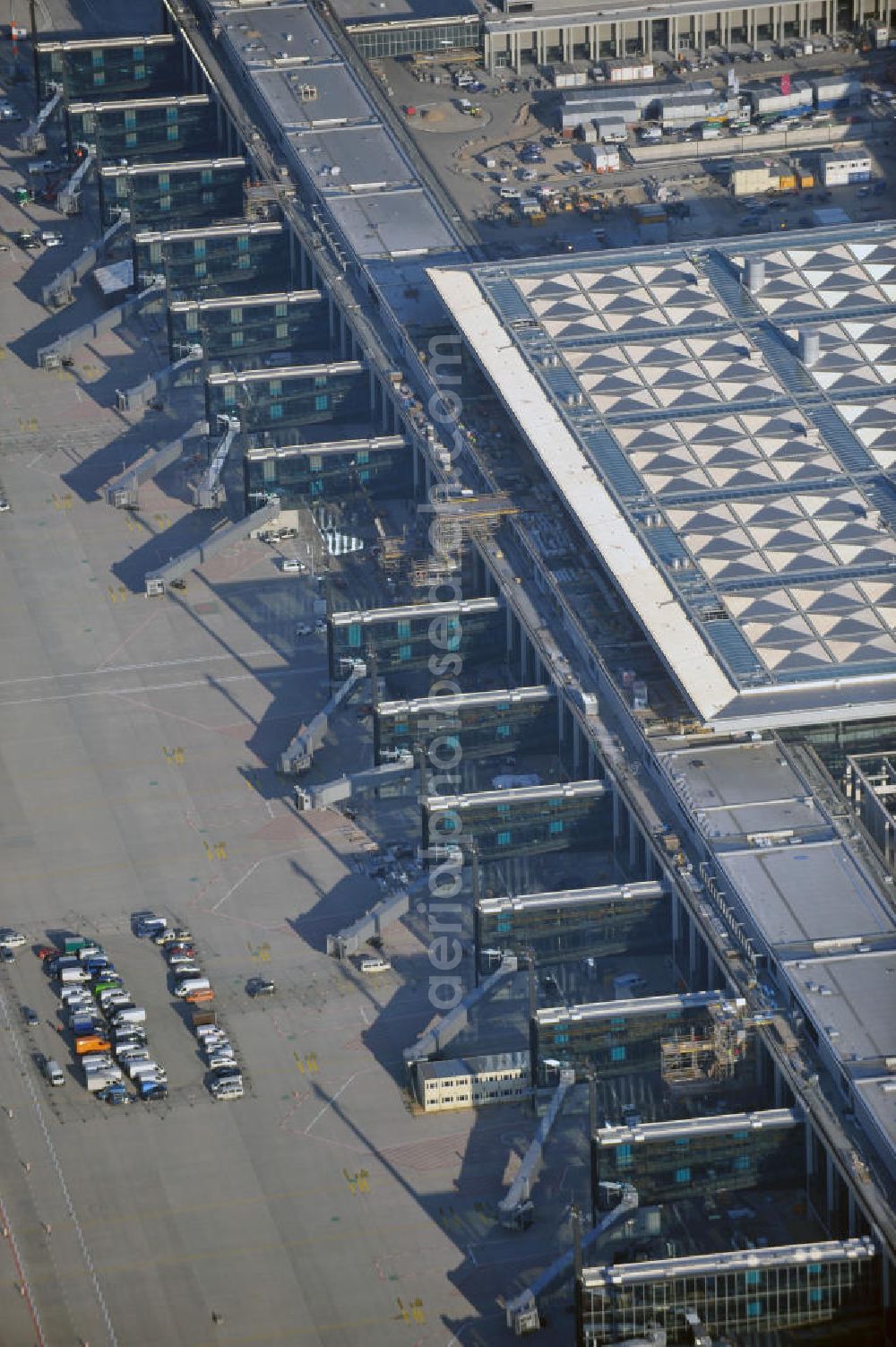 Schönefeld from above - Baustelle des fast fertigen Terminals am Flughafen Schönefeld (BBI). Der neue Terminal wird südlich des jetzigen Flughafens Berlin- Schönefeld errichtet. Der Flughafen Berlin Brandenburg (IATA Code BER , ICAO Code EDDB) wird ein internationaler Verkehrsflughafen auf dem Gebiet der Gemeinde Schönefeld im Land Brandenburg. Er trägt den Beinamen Willy Brandt und soll durch die Flughafen Berlin Brandenburg GmbH betrieben werden. Beteiligte Baufirmen sind die Hochtief AG; EUROVIA Beton; PORR; BERGER Bau; Karl Weiss; Matthai; Schäler Bau Berlin GmbH; STRABAG; Construction area of the new terminal at Schönefeld Airport (BBI). The new terminal is in the south of the airport Berlin -Schoenefeld quality built. Exporting companies: Hochtief AG; EUROVIA Beton; PORR; BERGER Bau; Karl Weiss; Matthai; Schäler Bau Berlin GmbH; STRABAG;