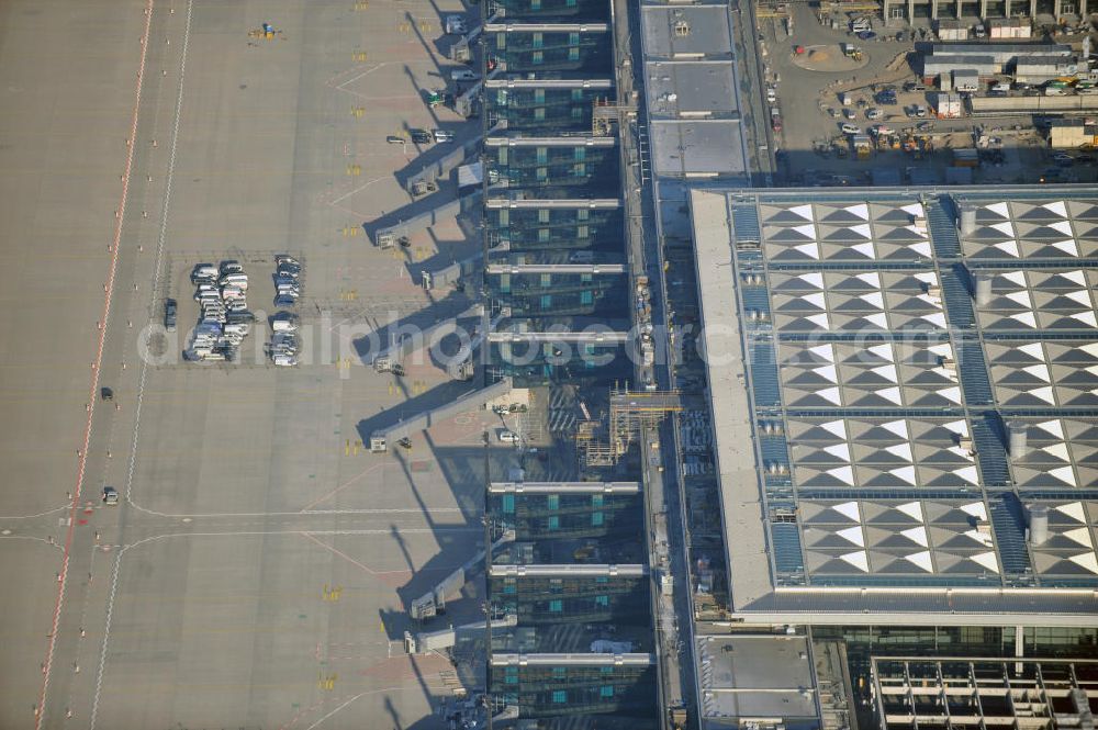 Aerial photograph Schönefeld - Baustelle des fast fertigen Terminals am Flughafen Schönefeld (BBI). Der neue Terminal wird südlich des jetzigen Flughafens Berlin- Schönefeld errichtet. Der Flughafen Berlin Brandenburg (IATA Code BER , ICAO Code EDDB) wird ein internationaler Verkehrsflughafen auf dem Gebiet der Gemeinde Schönefeld im Land Brandenburg. Er trägt den Beinamen Willy Brandt und soll durch die Flughafen Berlin Brandenburg GmbH betrieben werden. Beteiligte Baufirmen sind die Hochtief AG; EUROVIA Beton; PORR; BERGER Bau; Karl Weiss; Matthai; Schäler Bau Berlin GmbH; STRABAG; Construction area of the new terminal at Schönefeld Airport (BBI). The new terminal is in the south of the airport Berlin -Schoenefeld quality built. Exporting companies: Hochtief AG; EUROVIA Beton; PORR; BERGER Bau; Karl Weiss; Matthai; Schäler Bau Berlin GmbH; STRABAG;