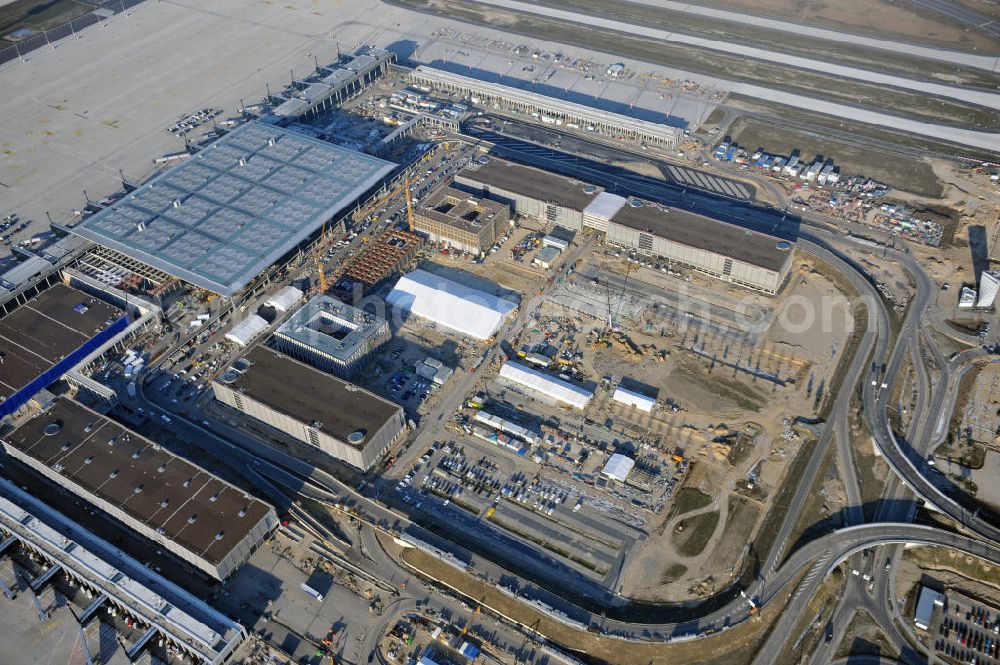 Aerial image Schönefeld - Baustelle des fast fertigen Terminals am Flughafen Schönefeld (BBI). Der neue Terminal wird südlich des jetzigen Flughafens Berlin- Schönefeld errichtet. Der Flughafen Berlin Brandenburg (IATA Code BER , ICAO Code EDDB) wird ein internationaler Verkehrsflughafen auf dem Gebiet der Gemeinde Schönefeld im Land Brandenburg. Er trägt den Beinamen Willy Brandt und soll durch die Flughafen Berlin Brandenburg GmbH betrieben werden. Beteiligte Baufirmen sind die Hochtief AG; EUROVIA Beton; PORR; BERGER Bau; Karl Weiss; Matthai; Schäler Bau Berlin GmbH; STRABAG; Construction area of the new terminal at Schönefeld Airport (BBI). The new terminal is in the south of the airport Berlin -Schoenefeld quality built. Exporting companies: Hochtief AG; EUROVIA Beton; PORR; BERGER Bau; Karl Weiss; Matthai; Schäler Bau Berlin GmbH; STRABAG;