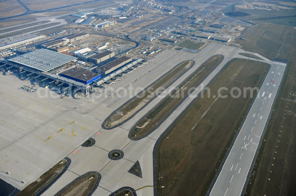 Schönefeld from above - Baustelle des fast fertigen Terminals am Flughafen Schönefeld (BBI). Der neue Terminal wird südlich des jetzigen Flughafens Berlin- Schönefeld errichtet. Der Flughafen Berlin Brandenburg (IATA Code BER , ICAO Code EDDB) wird ein internationaler Verkehrsflughafen auf dem Gebiet der Gemeinde Schönefeld im Land Brandenburg. Er trägt den Beinamen Willy Brandt und soll durch die Flughafen Berlin Brandenburg GmbH betrieben werden. Beteiligte Baufirmen sind die Hochtief AG; EUROVIA Beton; PORR; BERGER Bau; Karl Weiss; Matthai; Schäler Bau Berlin GmbH; STRABAG; Construction area of the new terminal at Schönefeld Airport (BBI). The new terminal is in the south of the airport Berlin -Schoenefeld quality built. Exporting companies: Hochtief AG; EUROVIA Beton; PORR; BERGER Bau; Karl Weiss; Matthai; Schäler Bau Berlin GmbH; STRABAG;