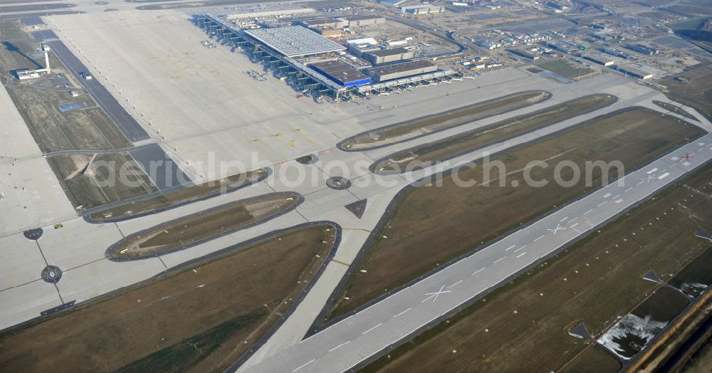 Schönefeld from the bird's eye view: Baustelle des fast fertigen Terminals am Flughafen Schönefeld (BBI). Der neue Terminal wird südlich des jetzigen Flughafens Berlin- Schönefeld errichtet. Der Flughafen Berlin Brandenburg (IATA Code BER , ICAO Code EDDB) wird ein internationaler Verkehrsflughafen auf dem Gebiet der Gemeinde Schönefeld im Land Brandenburg. Er trägt den Beinamen Willy Brandt und soll durch die Flughafen Berlin Brandenburg GmbH betrieben werden. Beteiligte Baufirmen sind die Hochtief AG; EUROVIA Beton; PORR; BERGER Bau; Karl Weiss; Matthai; Schäler Bau Berlin GmbH; STRABAG; Construction area of the new terminal at Schönefeld Airport (BBI). The new terminal is in the south of the airport Berlin -Schoenefeld quality built. Exporting companies: Hochtief AG; EUROVIA Beton; PORR; BERGER Bau; Karl Weiss; Matthai; Schäler Bau Berlin GmbH; STRABAG;