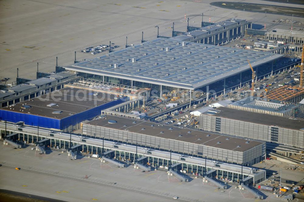 Schönefeld from above - Baustelle des fast fertigen Terminals am Flughafen Schönefeld (BBI). Der neue Terminal wird südlich des jetzigen Flughafens Berlin- Schönefeld errichtet. Der Flughafen Berlin Brandenburg (IATA Code BER , ICAO Code EDDB) wird ein internationaler Verkehrsflughafen auf dem Gebiet der Gemeinde Schönefeld im Land Brandenburg. Er trägt den Beinamen Willy Brandt und soll durch die Flughafen Berlin Brandenburg GmbH betrieben werden. Beteiligte Baufirmen sind die Hochtief AG; EUROVIA Beton; PORR; BERGER Bau; Karl Weiss; Matthai; Schäler Bau Berlin GmbH; STRABAG; Construction area of the new terminal at Schönefeld Airport (BBI). The new terminal is in the south of the airport Berlin -Schoenefeld quality built. Exporting companies: Hochtief AG; EUROVIA Beton; PORR; BERGER Bau; Karl Weiss; Matthai; Schäler Bau Berlin GmbH; STRABAG;