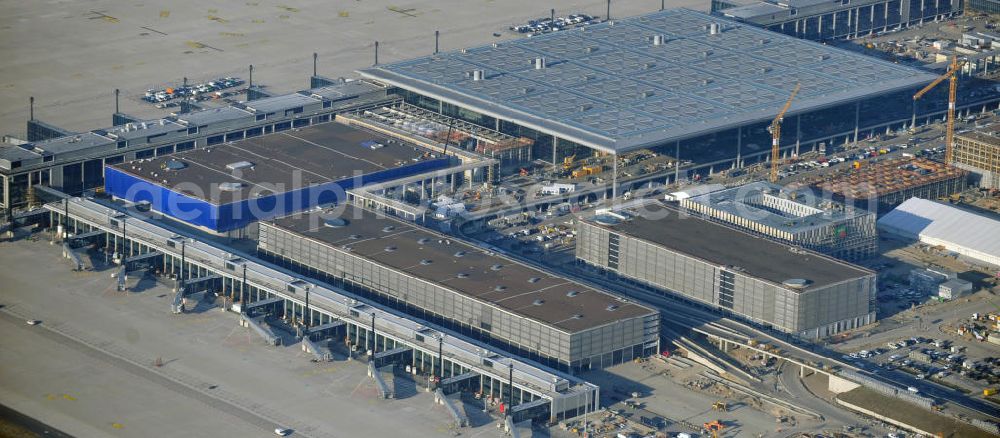 Schönefeld from the bird's eye view: Baustelle des fast fertigen Terminals am Flughafen Schönefeld (BBI). Der neue Terminal wird südlich des jetzigen Flughafens Berlin- Schönefeld errichtet. Der Flughafen Berlin Brandenburg (IATA Code BER , ICAO Code EDDB) wird ein internationaler Verkehrsflughafen auf dem Gebiet der Gemeinde Schönefeld im Land Brandenburg. Er trägt den Beinamen Willy Brandt und soll durch die Flughafen Berlin Brandenburg GmbH betrieben werden. Beteiligte Baufirmen sind die Hochtief AG; EUROVIA Beton; PORR; BERGER Bau; Karl Weiss; Matthai; Schäler Bau Berlin GmbH; STRABAG; Construction area of the new terminal at Schönefeld Airport (BBI). The new terminal is in the south of the airport Berlin -Schoenefeld quality built. Exporting companies: Hochtief AG; EUROVIA Beton; PORR; BERGER Bau; Karl Weiss; Matthai; Schäler Bau Berlin GmbH; STRABAG;