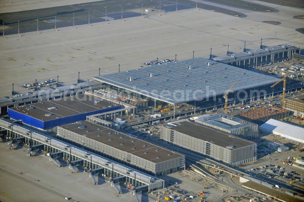 Aerial image Schönefeld - Baustelle des fast fertigen Terminals am Flughafen Schönefeld (BBI). Der neue Terminal wird südlich des jetzigen Flughafens Berlin- Schönefeld errichtet. Der Flughafen Berlin Brandenburg (IATA Code BER , ICAO Code EDDB) wird ein internationaler Verkehrsflughafen auf dem Gebiet der Gemeinde Schönefeld im Land Brandenburg. Er trägt den Beinamen Willy Brandt und soll durch die Flughafen Berlin Brandenburg GmbH betrieben werden. Beteiligte Baufirmen sind die Hochtief AG; EUROVIA Beton; PORR; BERGER Bau; Karl Weiss; Matthai; Schäler Bau Berlin GmbH; STRABAG; Construction area of the new terminal at Schönefeld Airport (BBI). The new terminal is in the south of the airport Berlin -Schoenefeld quality built. Exporting companies: Hochtief AG; EUROVIA Beton; PORR; BERGER Bau; Karl Weiss; Matthai; Schäler Bau Berlin GmbH; STRABAG;