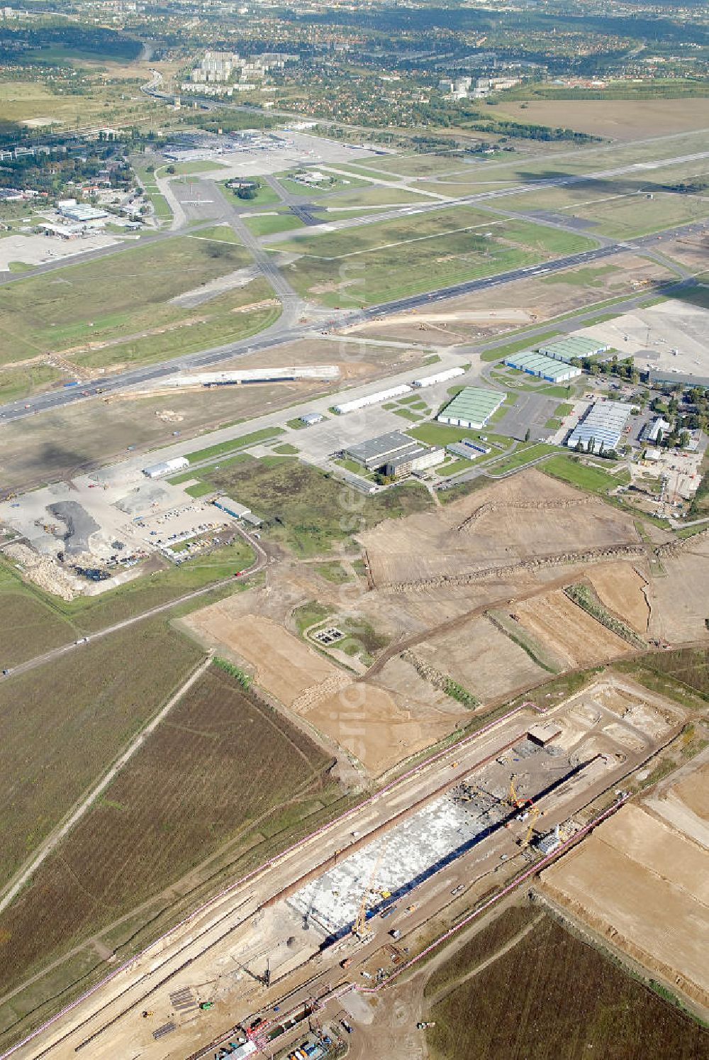 Schönefeld from the bird's eye view: Baustelle des neuen Terminals am Flughafen Schönefeld (BBI). Der neue Terminal wird südlich des jetzigen Flughafens Berlin- Schönefeld errichtet. Ausführende Firmen: Hochtief AG; EUROVIA Beton; PORR; BERGER Bau; Karl Weiss; Matthai; Schäler Bau Berlin GmbH; STRABAG; MAX BÖGL. Construction area of the new terminal at Schönefeld Airport (BBI). The new terminal is in the south of the airport Berlin-Schoenefeld quality built. Exporting companies: Hochtief AG; EUROVIA Beton; PORR; BERGER Bau; Karl Weiss; Matthai; Schäler Bau Berlin GmbH; STRABAG; MAX BÖGL.