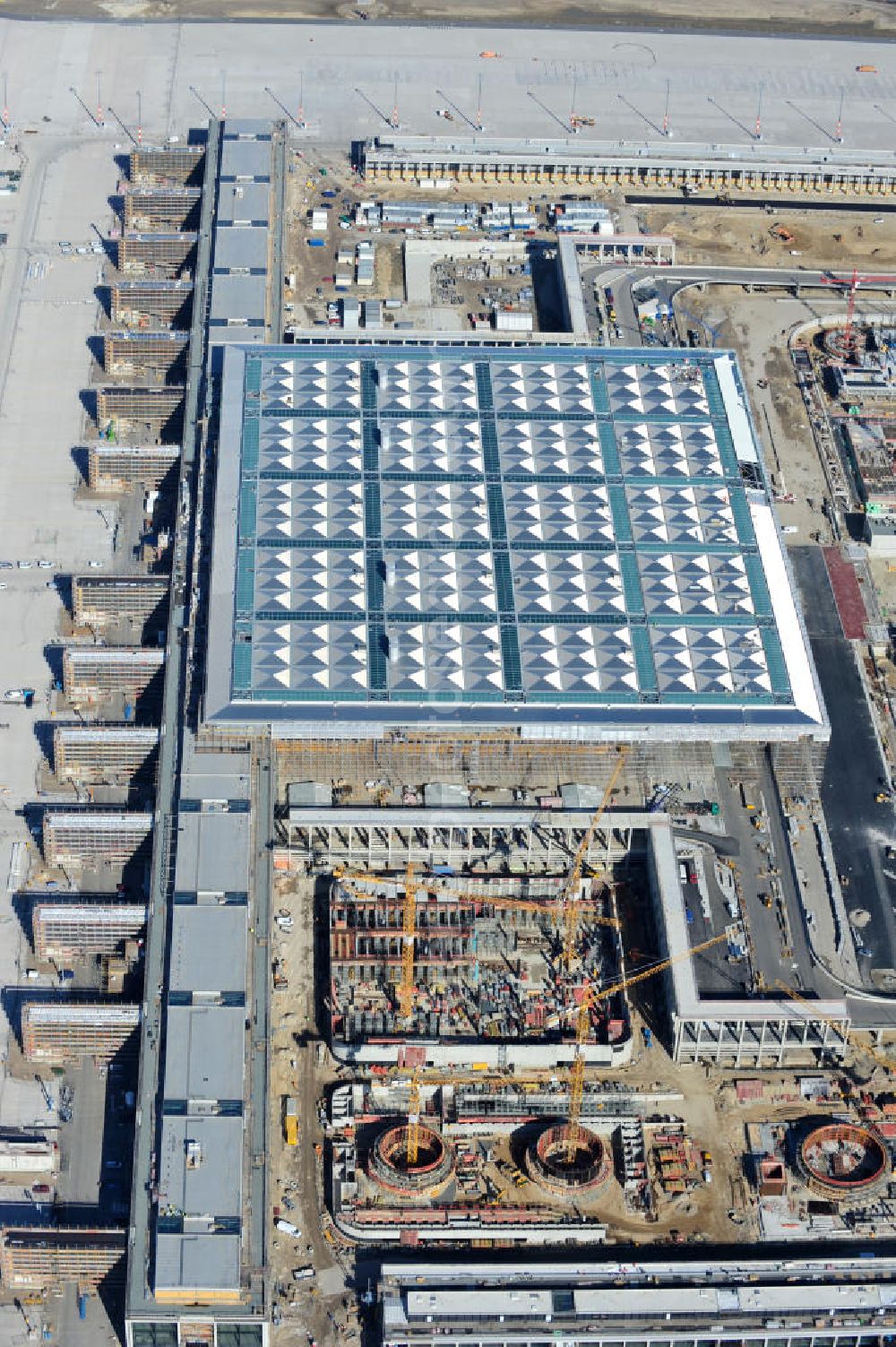 Schönefeld from the bird's eye view: Baustelle des neuen Terminals am Flughafen Schönefeld (BBI). Der neue Terminal wird südlich des jetzigen Flughafens Berlin- Schönefeld errichtet. Ausführende Firmen: Hochtief AG; EUROVIA Beton; PORR; BERGER Bau; Karl Weiss; Matthai; Schäler Bau Berlin GmbH; STRABAG; Construction area of the new terminal at Schönefeld Airport (BBI). The new terminal is in the south of the airport Berlin-Schoenefeld quality built. Exporting companies: Hochtief AG; EUROVIA Beton; PORR; BERGER Bau; Karl Weiss; Matthai; Schäler Bau Berlin GmbH; STRABAG;