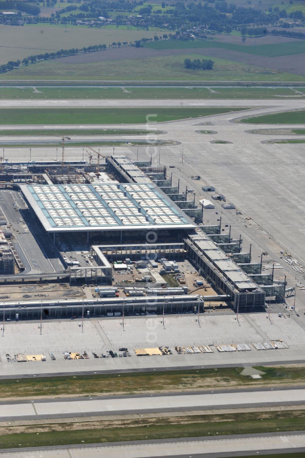 Aerial photograph Schönefeld - Baustelle des neuen Terminals am Flughafen Schönefeld (BBI). Der neue Terminal wird südlich des jetzigen Flughafens Berlin- Schönefeld errichtet. Ausführende Firmen: Hochtief AG; EUROVIA Beton; PORR; BERGER Bau; Karl Weiss; Matthai; Schäler Bau Berlin GmbH; STRABAG; Construction area of the new terminal at Schönefeld Airport (BBI). The new terminal is in the south of the airport Berlin-Schoenefeld quality built. Exporting companies: Hochtief AG; EUROVIA Beton; PORR; BERGER Bau; Karl Weiss; Matthai; Schäler Bau Berlin GmbH; STRABAG;