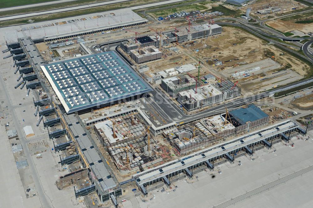 Aerial photograph Schönefeld - Baustelle des neuen Terminals am Flughafen Schönefeld (BBI). Der neue Terminal wird südlich des jetzigen Flughafens Berlin- Schönefeld errichtet. Ausführende Firmen: Hochtief AG; EUROVIA Beton; PORR; BERGER Bau; Karl Weiss; Matthai; Schäler Bau Berlin GmbH; STRABAG; Construction area of the new terminal at Schönefeld Airport (BBI). The new terminal is in the south of the airport Berlin-Schoenefeld quality built. Exporting companies: Hochtief AG; EUROVIA Beton; PORR; BERGER Bau; Karl Weiss; Matthai; Schäler Bau Berlin GmbH; STRABAG;