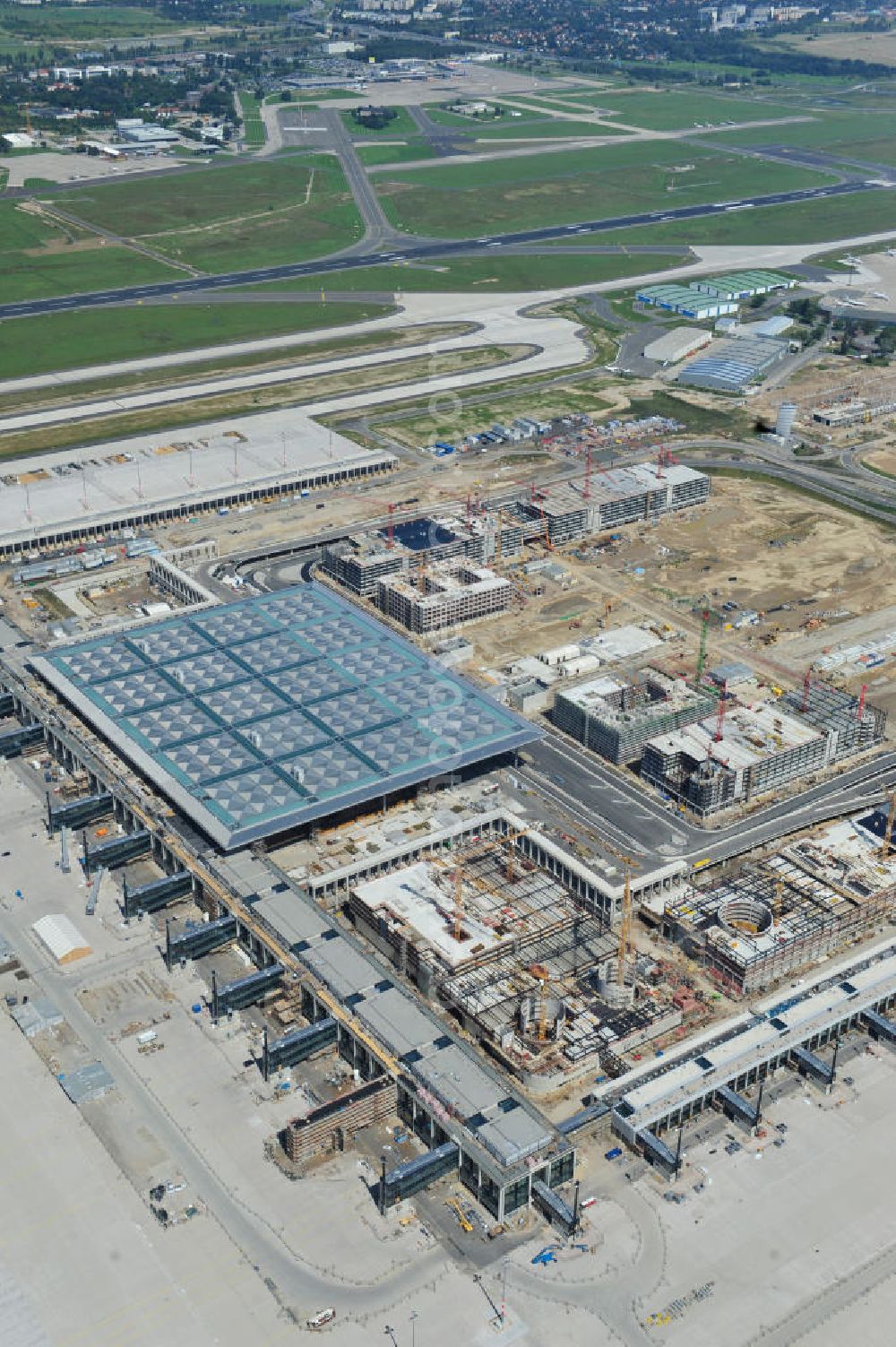 Schönefeld from the bird's eye view: Baustelle des neuen Terminals am Flughafen Schönefeld (BBI). Der neue Terminal wird südlich des jetzigen Flughafens Berlin- Schönefeld errichtet. Ausführende Firmen: Hochtief AG; EUROVIA Beton; PORR; BERGER Bau; Karl Weiss; Matthai; Schäler Bau Berlin GmbH; STRABAG; Construction area of the new terminal at Schönefeld Airport (BBI). The new terminal is in the south of the airport Berlin-Schoenefeld quality built. Exporting companies: Hochtief AG; EUROVIA Beton; PORR; BERGER Bau; Karl Weiss; Matthai; Schäler Bau Berlin GmbH; STRABAG;