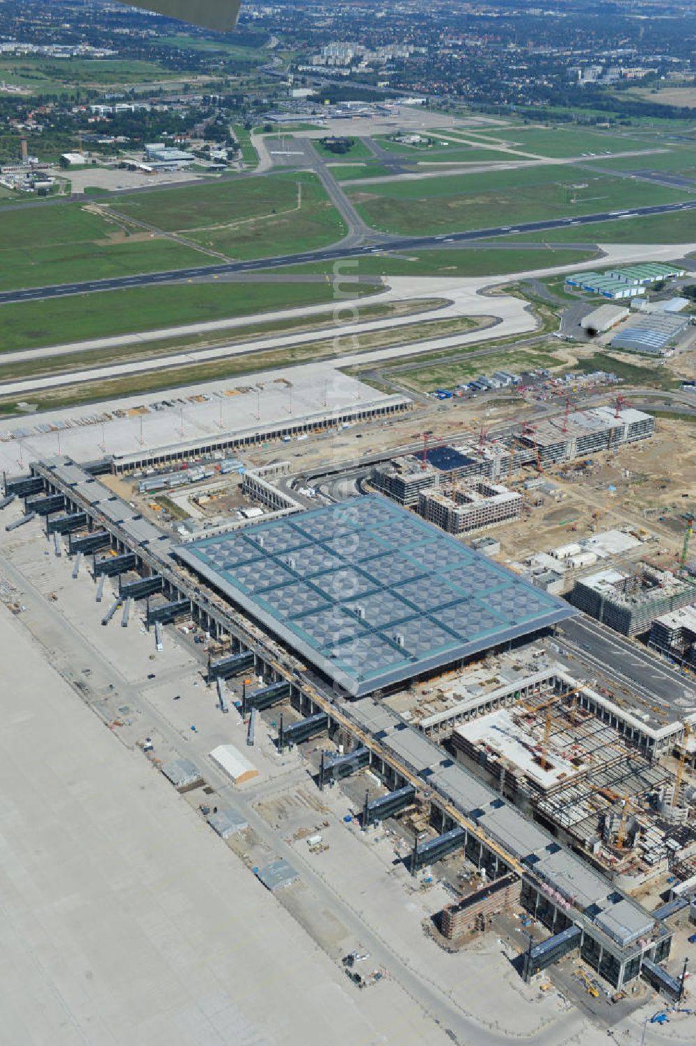 Aerial photograph Schönefeld - Baustelle des neuen Terminals am Flughafen Schönefeld (BBI). Der neue Terminal wird südlich des jetzigen Flughafens Berlin- Schönefeld errichtet. Ausführende Firmen: Hochtief AG; EUROVIA Beton; PORR; BERGER Bau; Karl Weiss; Matthai; Schäler Bau Berlin GmbH; STRABAG; Construction area of the new terminal at Schönefeld Airport (BBI). The new terminal is in the south of the airport Berlin-Schoenefeld quality built. Exporting companies: Hochtief AG; EUROVIA Beton; PORR; BERGER Bau; Karl Weiss; Matthai; Schäler Bau Berlin GmbH; STRABAG;