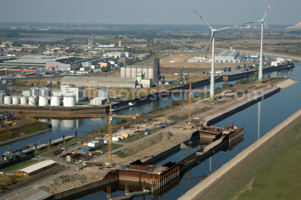 Magdeburg from above - Blick auf die Baustelle der Niedrigwasserschleuse an der Steinkopfinsel im Hafen Magdeburg an der Elbe. Umflossen wird die Steinkopfinsel im Osten von der Elbe und dem Abstiegskanal Rothensee, sowie im Westen vom Zweigkanal Magdeburg. Die Insel ist ca. 2,5 km lang und ca. 0,3 km breit (an der stärksten Stelle). Der Binnenhafen ist in vier Güterumschlagplätze eingeteilt, der Handelshafen, Industriehafen, Kanalhafen und der Hanseshafen. Das Gebiet verteilt sich über die Stadtteile Alte-Neustadt, Industriehafen und Gewerbegebiet Nord. Jedoch hat der Handelshafen für die Schiffahrt heute keine Bedeutung mehr, dieser Bereich wird stetig zum Wissenschaftsstandort umgebaut. Kontakt: Magdeburger Hafen GmbH, Saalestraße 20, 39126 Magdeburg, Tel. +49(0)391 5939-0, Fax +49(0)391 5616648, email: Logistik@magdeburg-hafen.de; Kontakt WSV: Wasserstraßen-Neubauamt Magdeburg, 39106 Magdeburg, Tel. +49(0)391 535-0, email: wna-magdeburg@wsv.bund.de