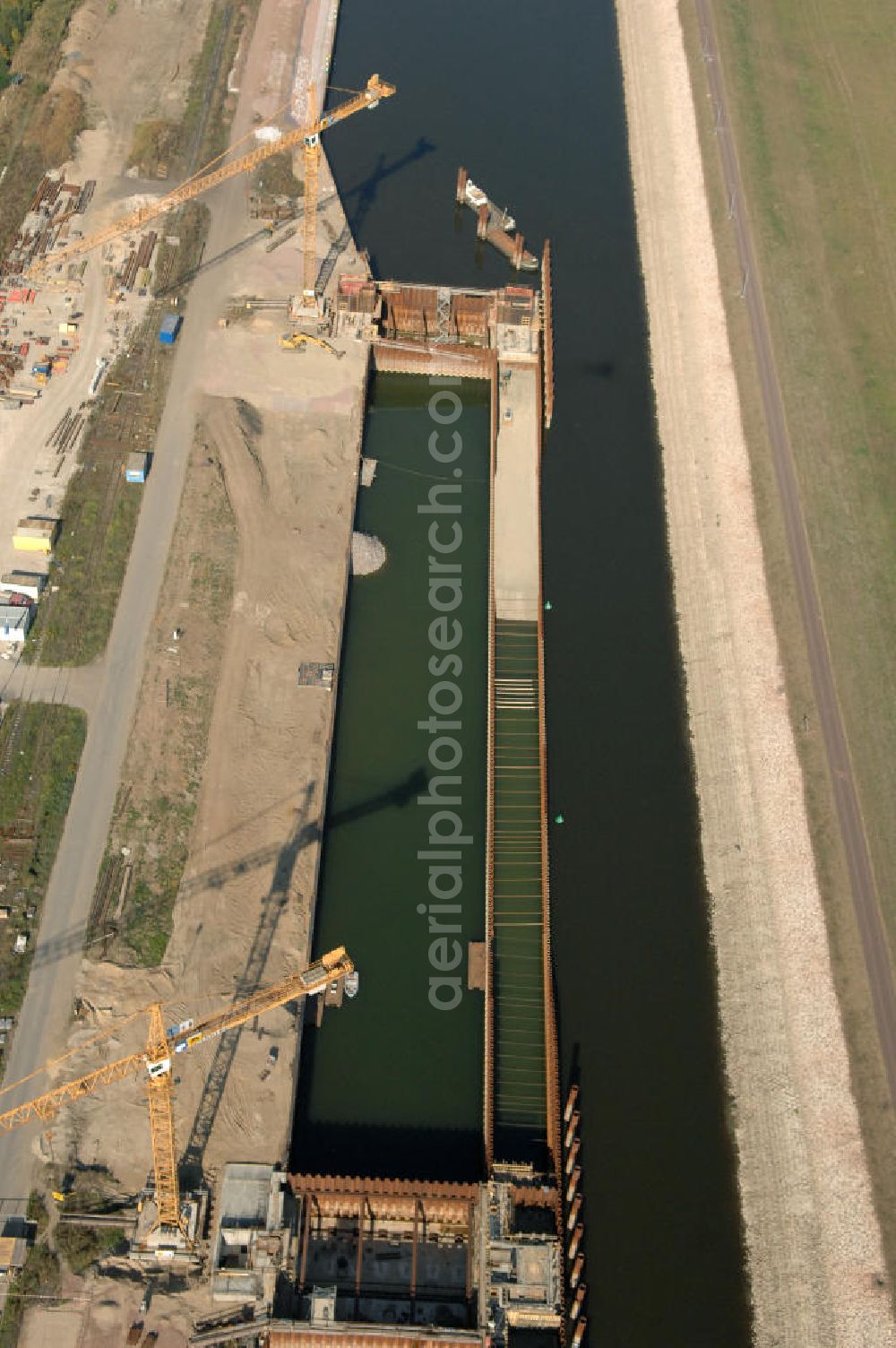 Magdeburg from the bird's eye view: Blick auf die Baustelle der Niedrigwasserschleuse an der Steinkopfinsel im Hafen Magdeburg an der Elbe. Umflossen wird die Steinkopfinsel im Osten von der Elbe und dem Abstiegskanal Rothensee, sowie im Westen vom Zweigkanal Magdeburg. Die Insel ist ca. 2,5 km lang und ca. 0,3 km breit (an der stärksten Stelle). Der Binnenhafen ist in vier Güterumschlagplätze eingeteilt, der Handelshafen, Industriehafen, Kanalhafen und der Hanseshafen. Das Gebiet verteilt sich über die Stadtteile Alte-Neustadt, Industriehafen und Gewerbegebiet Nord. Jedoch hat der Handelshafen für die Schiffahrt heute keine Bedeutung mehr, dieser Bereich wird stetig zum Wissenschaftsstandort umgebaut. Kontakt: Magdeburger Hafen GmbH, Saalestraße 20, 39126 Magdeburg, Tel. +49(0)391 5939-0, Fax +49(0)391 5616648, email: Logistik@magdeburg-hafen.de; Kontakt WSV: Wasserstraßen-Neubauamt Magdeburg, 39106 Magdeburg, Tel. +49(0)391 535-0, email: wna-magdeburg@wsv.bund.de