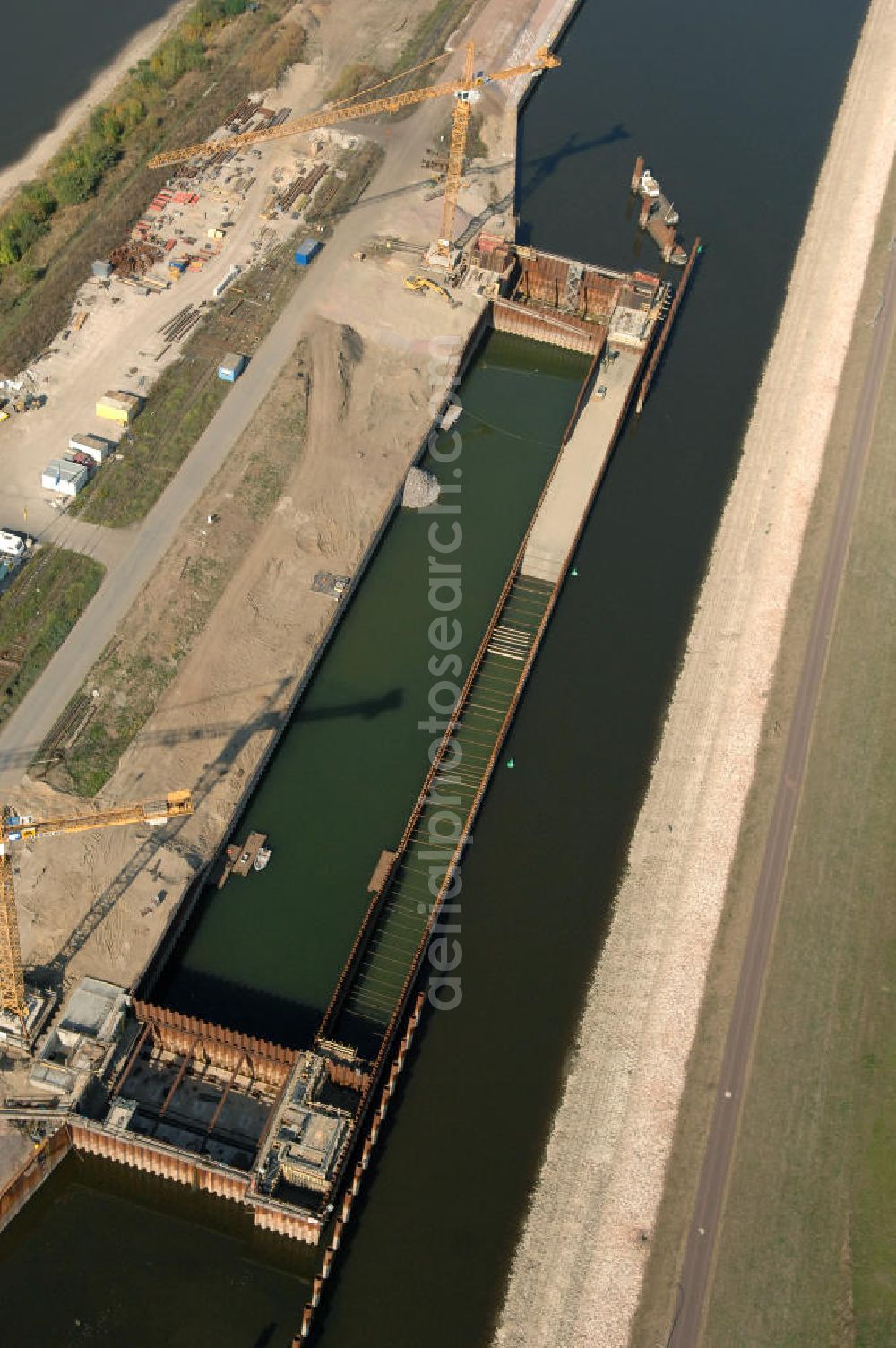 Aerial image Magdeburg - Blick auf die Baustelle der Niedrigwasserschleuse an der Steinkopfinsel im Hafen Magdeburg an der Elbe. Umflossen wird die Steinkopfinsel im Osten von der Elbe und dem Abstiegskanal Rothensee, sowie im Westen vom Zweigkanal Magdeburg. Die Insel ist ca. 2,5 km lang und ca. 0,3 km breit (an der stärksten Stelle). Der Binnenhafen ist in vier Güterumschlagplätze eingeteilt, der Handelshafen, Industriehafen, Kanalhafen und der Hanseshafen. Das Gebiet verteilt sich über die Stadtteile Alte-Neustadt, Industriehafen und Gewerbegebiet Nord. Jedoch hat der Handelshafen für die Schiffahrt heute keine Bedeutung mehr, dieser Bereich wird stetig zum Wissenschaftsstandort umgebaut. Kontakt: Magdeburger Hafen GmbH, Saalestraße 20, 39126 Magdeburg, Tel. +49(0)391 5939-0, Fax +49(0)391 5616648, email: Logistik@magdeburg-hafen.de; Kontakt WSV: Wasserstraßen-Neubauamt Magdeburg, 39106 Magdeburg, Tel. +49(0)391 535-0, email: wna-magdeburg@wsv.bund.de