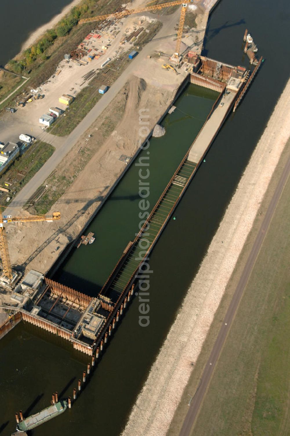 Aerial photograph Magdeburg - Blick auf die Baustelle der Niedrigwasserschleuse an der Steinkopfinsel im Hafen Magdeburg an der Elbe. Umflossen wird die Steinkopfinsel im Osten von der Elbe und dem Abstiegskanal Rothensee, sowie im Westen vom Zweigkanal Magdeburg. Die Insel ist ca. 2,5 km lang und ca. 0,3 km breit (an der stärksten Stelle). Der Binnenhafen ist in vier Güterumschlagplätze eingeteilt, der Handelshafen, Industriehafen, Kanalhafen und der Hanseshafen. Das Gebiet verteilt sich über die Stadtteile Alte-Neustadt, Industriehafen und Gewerbegebiet Nord. Jedoch hat der Handelshafen für die Schiffahrt heute keine Bedeutung mehr, dieser Bereich wird stetig zum Wissenschaftsstandort umgebaut. Kontakt: Magdeburger Hafen GmbH, Saalestraße 20, 39126 Magdeburg, Tel. +49(0)391 5939-0, Fax +49(0)391 5616648, email: Logistik@magdeburg-hafen.de; Kontakt WSV: Wasserstraßen-Neubauamt Magdeburg, 39106 Magdeburg, Tel. +49(0)391 535-0, email: wna-magdeburg@wsv.bund.de