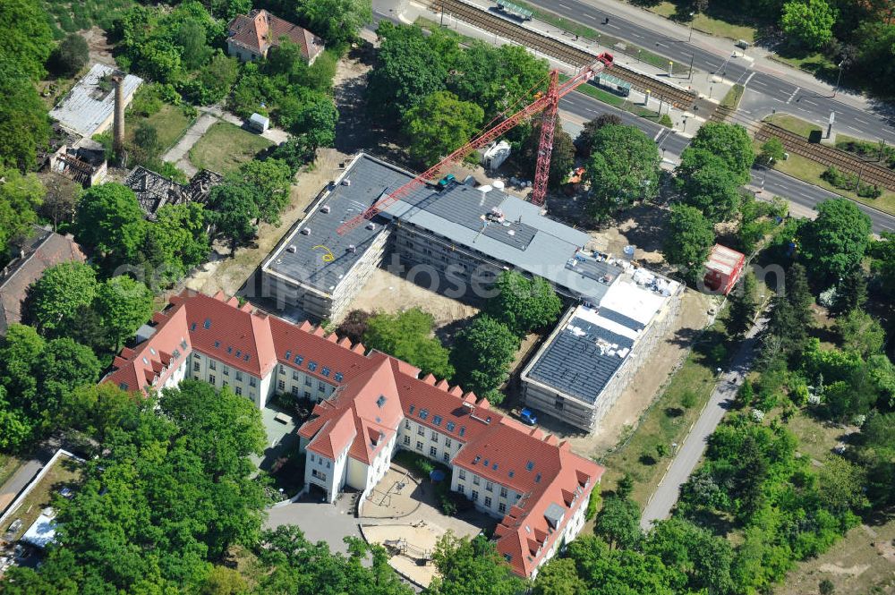 Berlin Karlshorst from the bird's eye view: Gelände des ehemaligen evangelischen Diakoniewerk Königin Elisabeth an der Treskowallee in Karlshorst. Zwischen 1945 und 1991 diente es der Sowjetischen Armee als Militärhospital. Der bereits sanierte Trakt beinhaltet heute die Albatros-Schule, Förderschule für geistig Behinderte. Im sich in der Sanierung befindlichen Teil entsteht ein Altenpflegeheim. Ein Projekt der Hiba Hamburger Immobilien & Bauträger Aktiengesellschaft, der EDG Grundbesitzgesellschaft, eine Gesellschaft der Kieler EDG Immobilien (Bauherr). Betreiber wird die Diakonie-Pflege Neukölln. Albatros-School, special school for people with mental handicaps, and the construction site for a nursing home for the elderly at the street Treskowalle in the Berlin district Karlshorst.